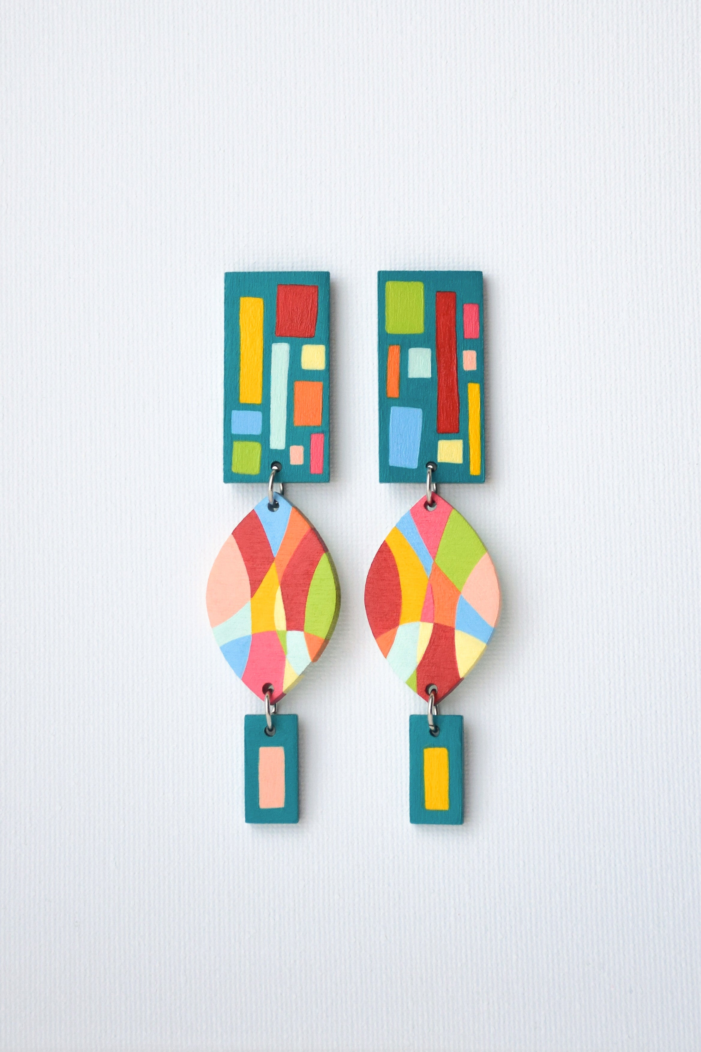 Colorful hand-painted geometric earrings on a light gray background