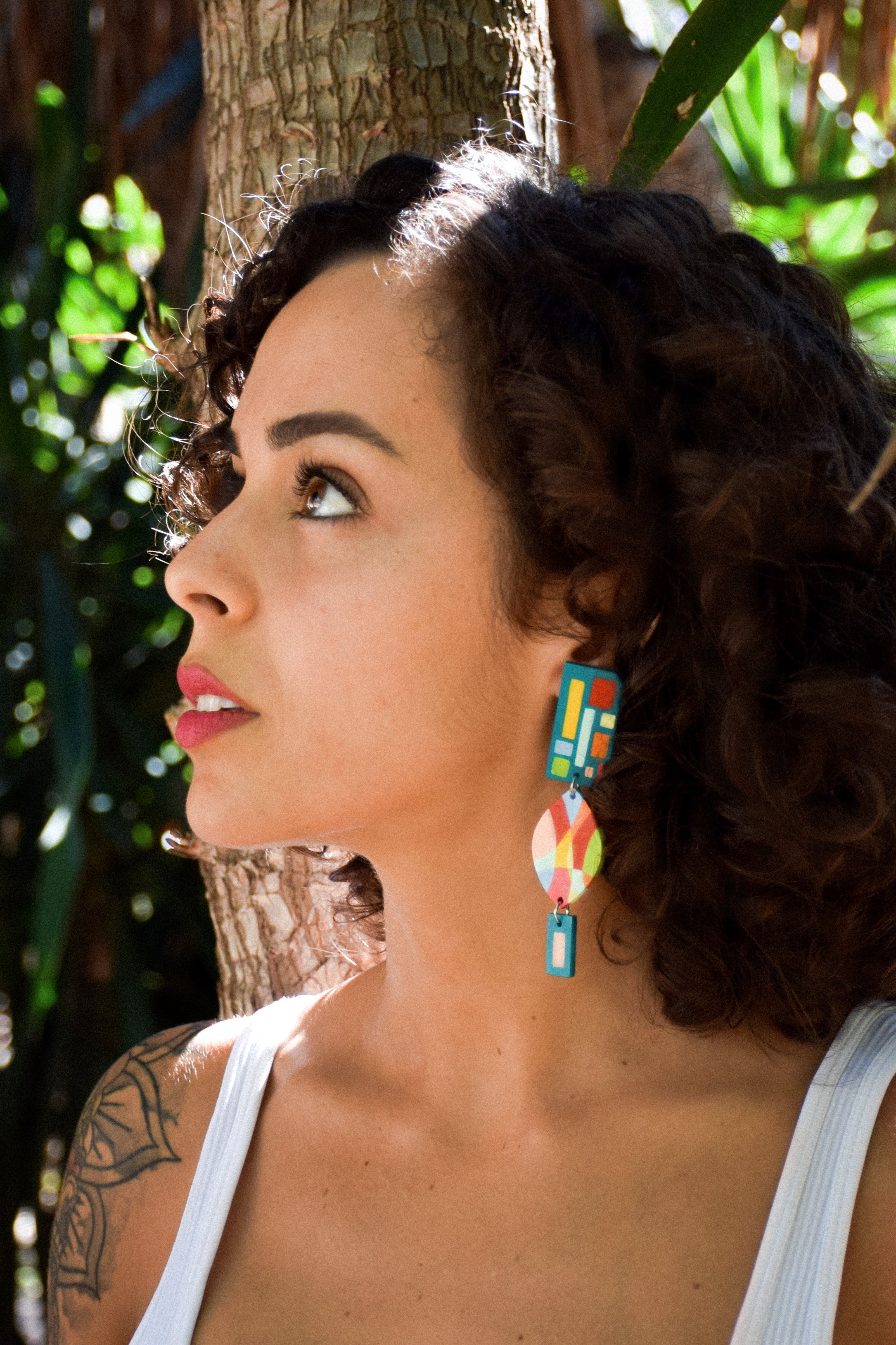 Woman wearing colorful earrings with a natural background