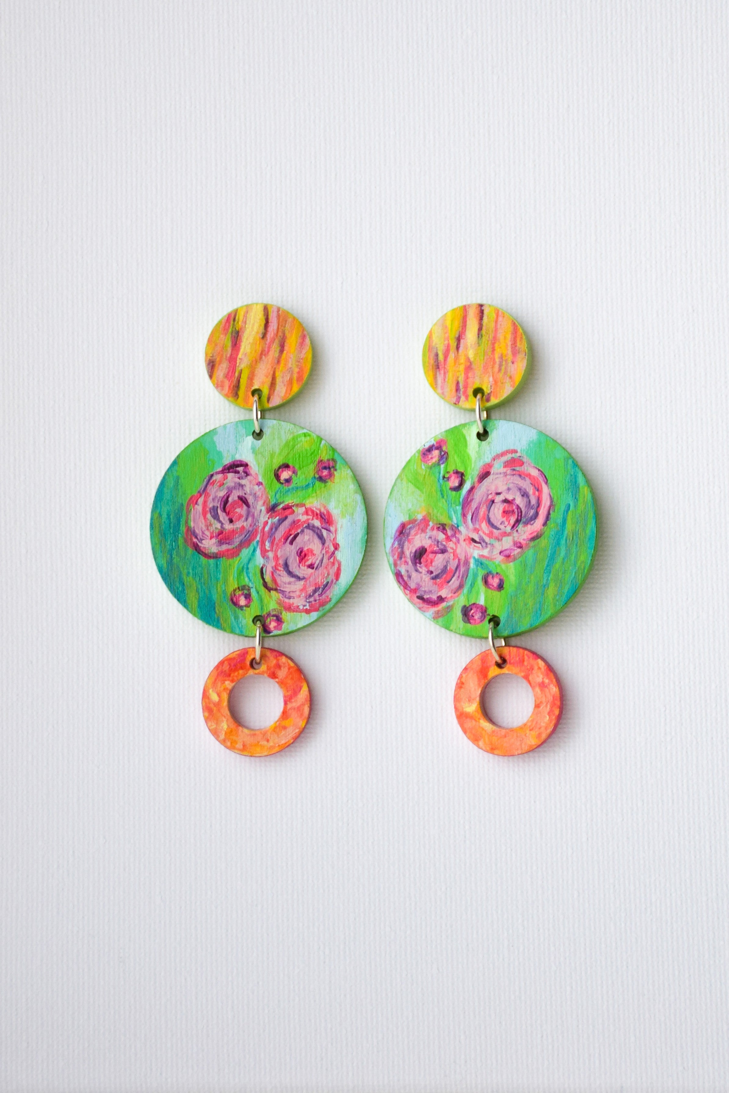 Colorful hand-painted floral earrings on a light gray background