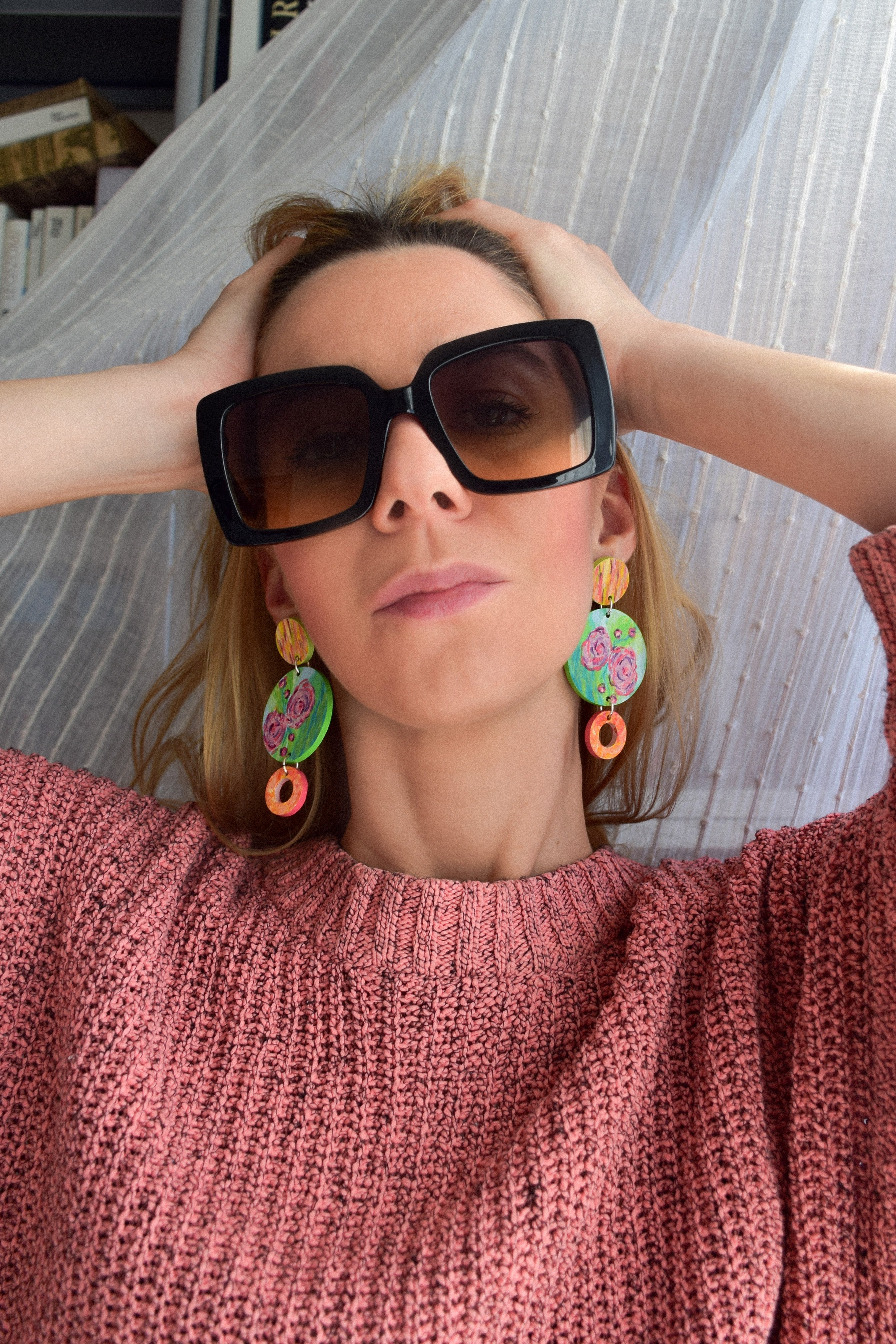 Woman wearing sunglasses and colorful earrings. 