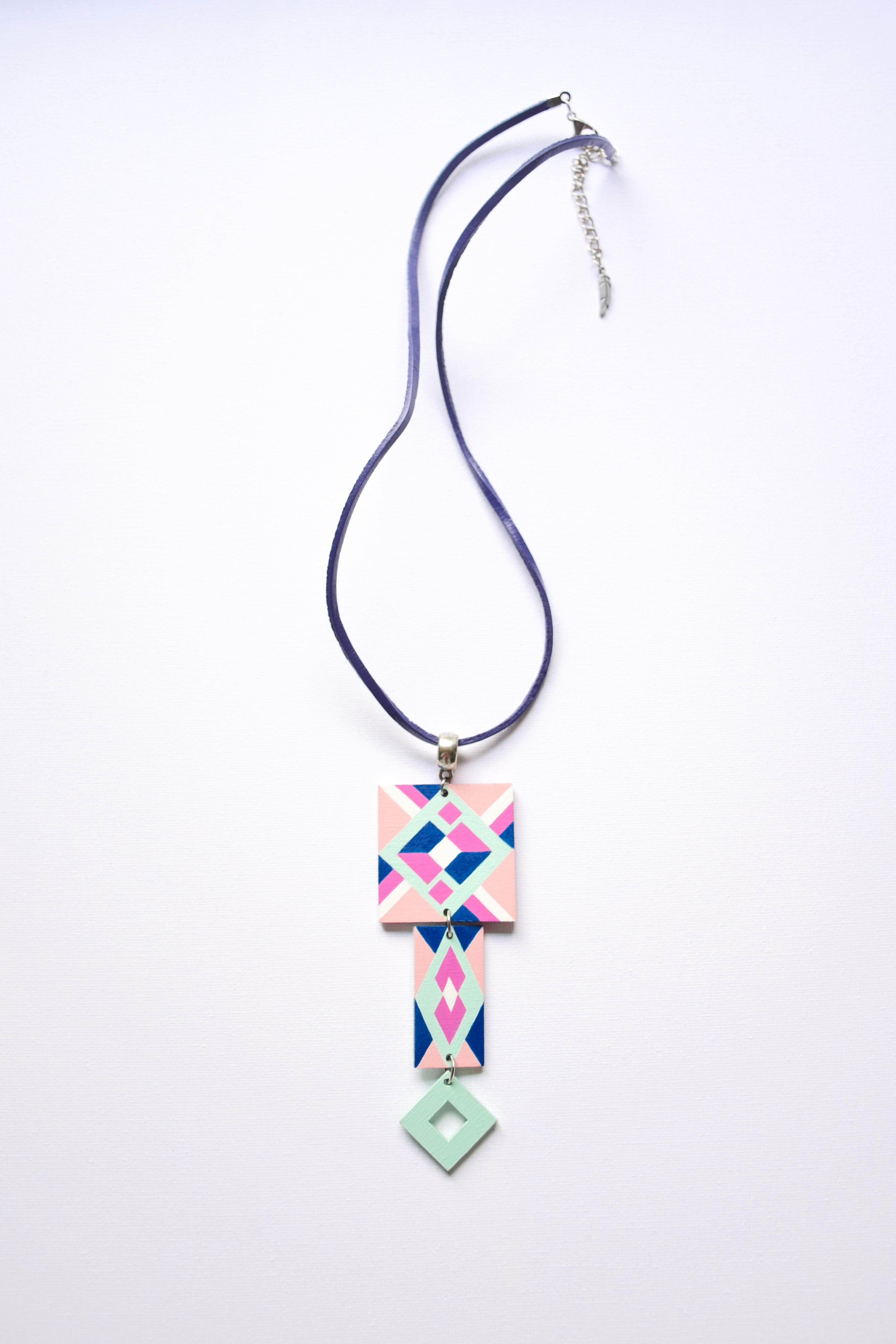 Leather cord necklace with a geometric hand-painted pendant on a white background