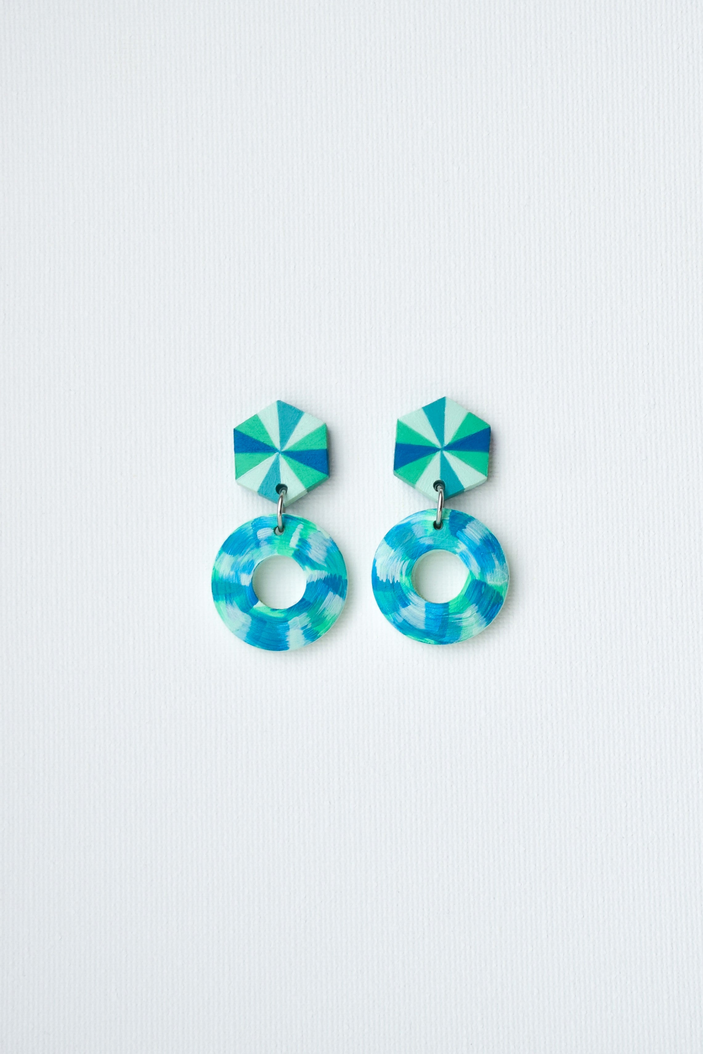 Pair of blue and green earrings on a light gray background