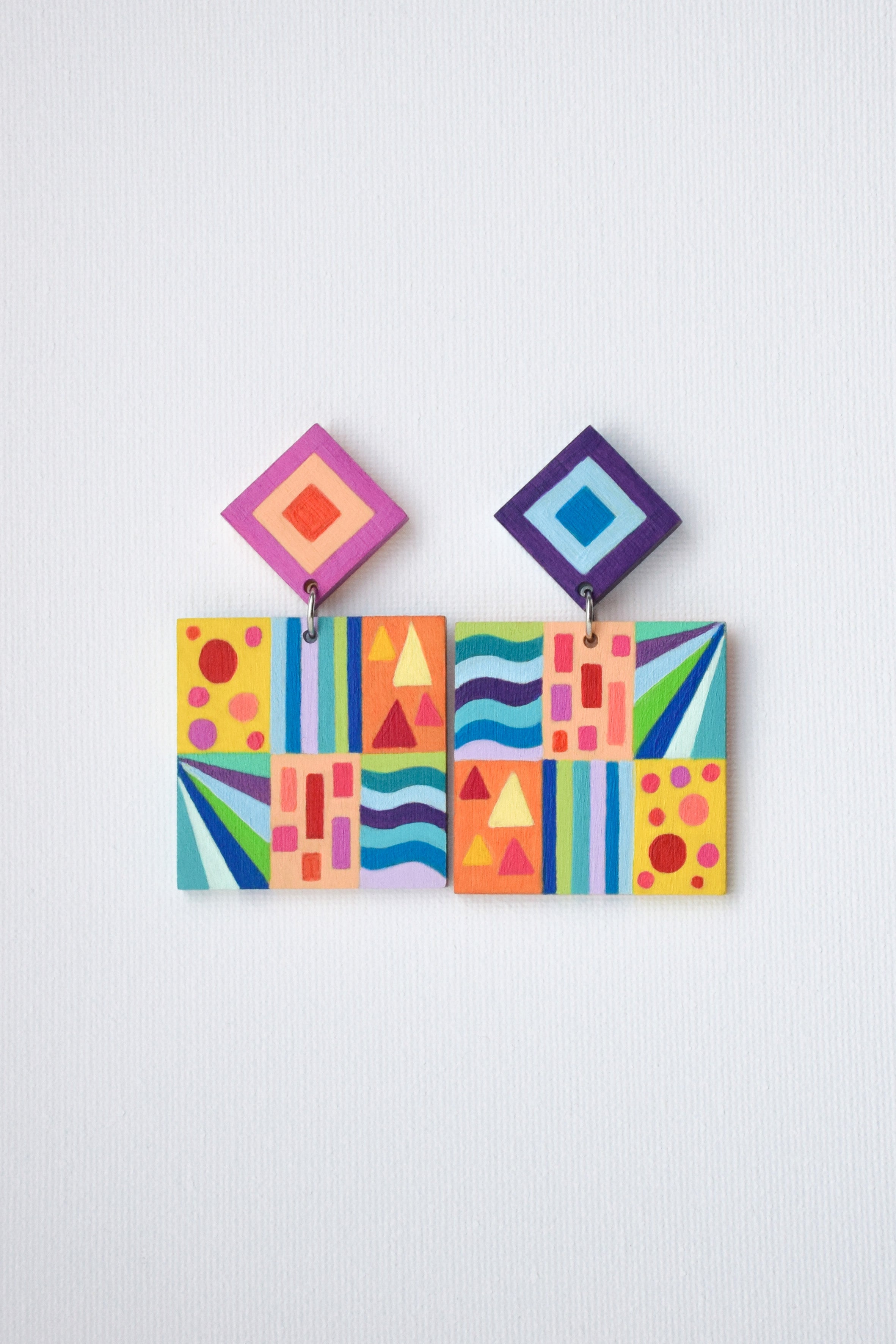Colorful geometric patterned earrings on a white background