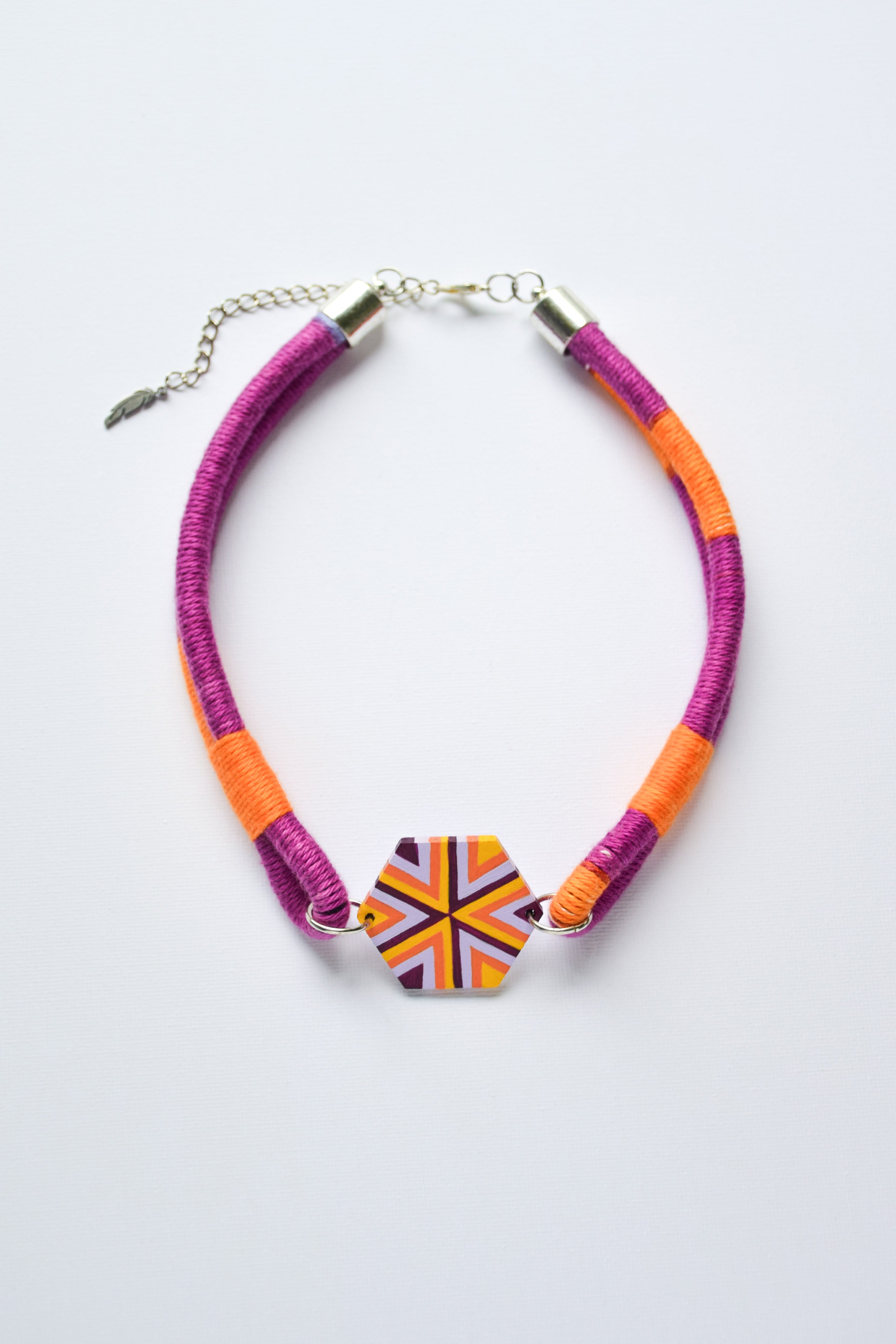 Colorful necklace with a geometric pendant on a white background