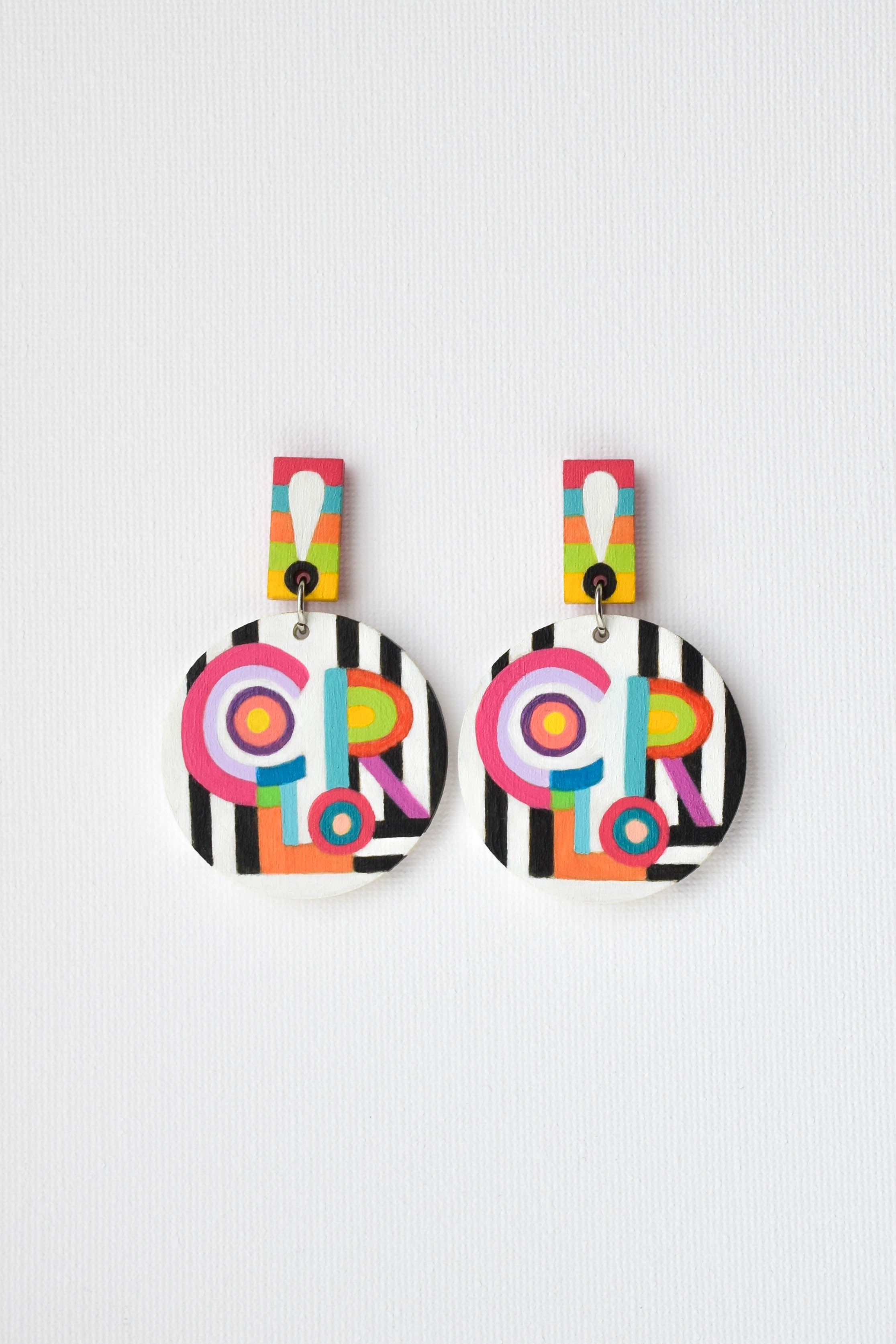 Pair of colorful earrings with painted 'COLOR' text on a white background