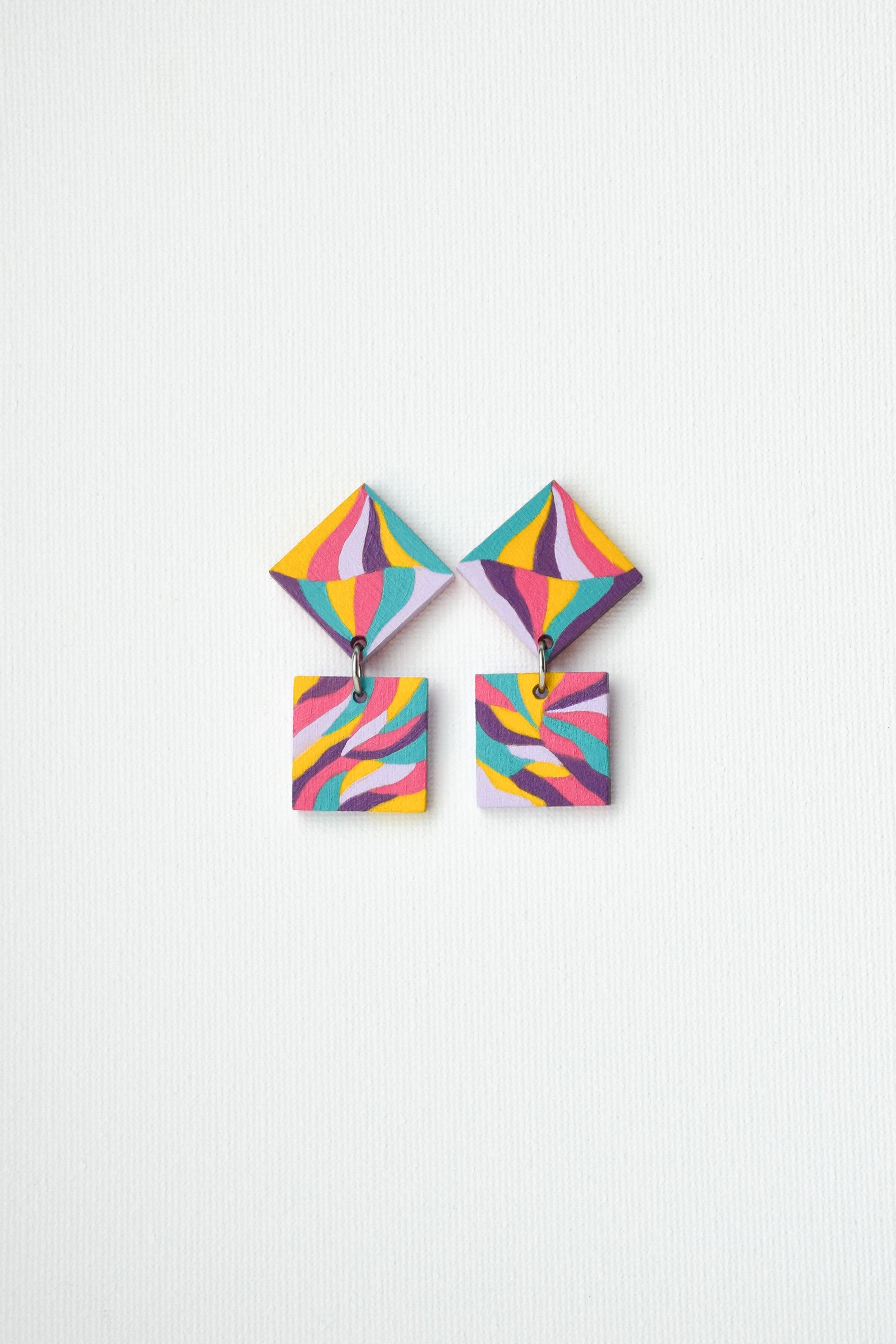 Colorful hand-painted geometric earrings on a white background