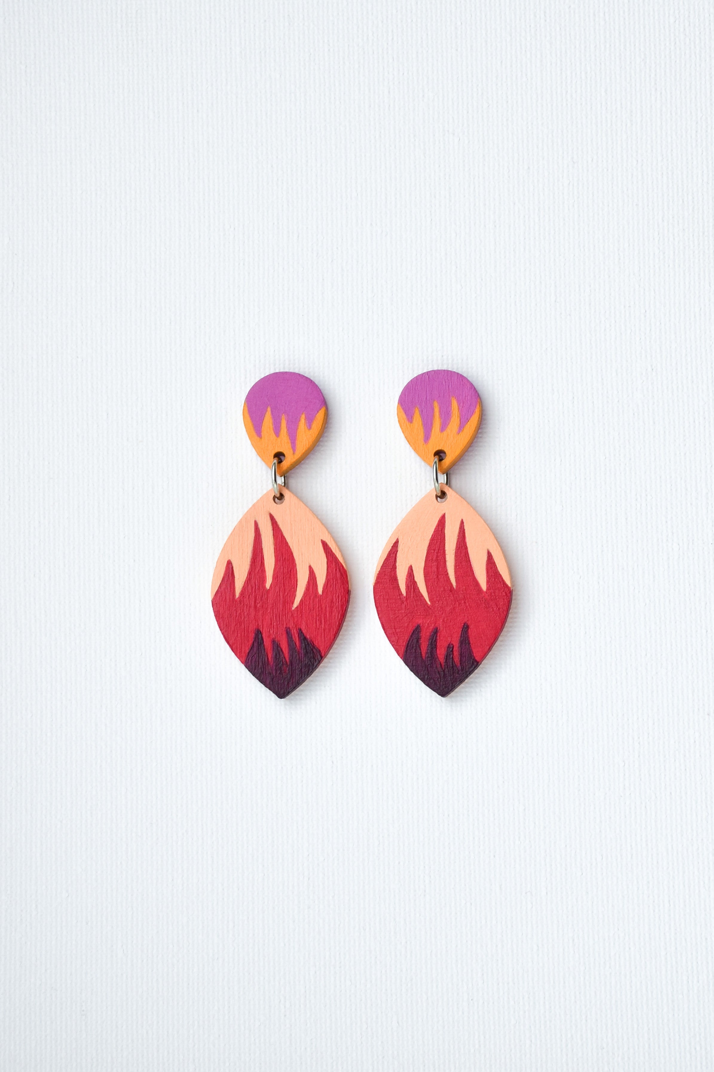 Colorful hand-painted earrings with a gradient design on a light gray background