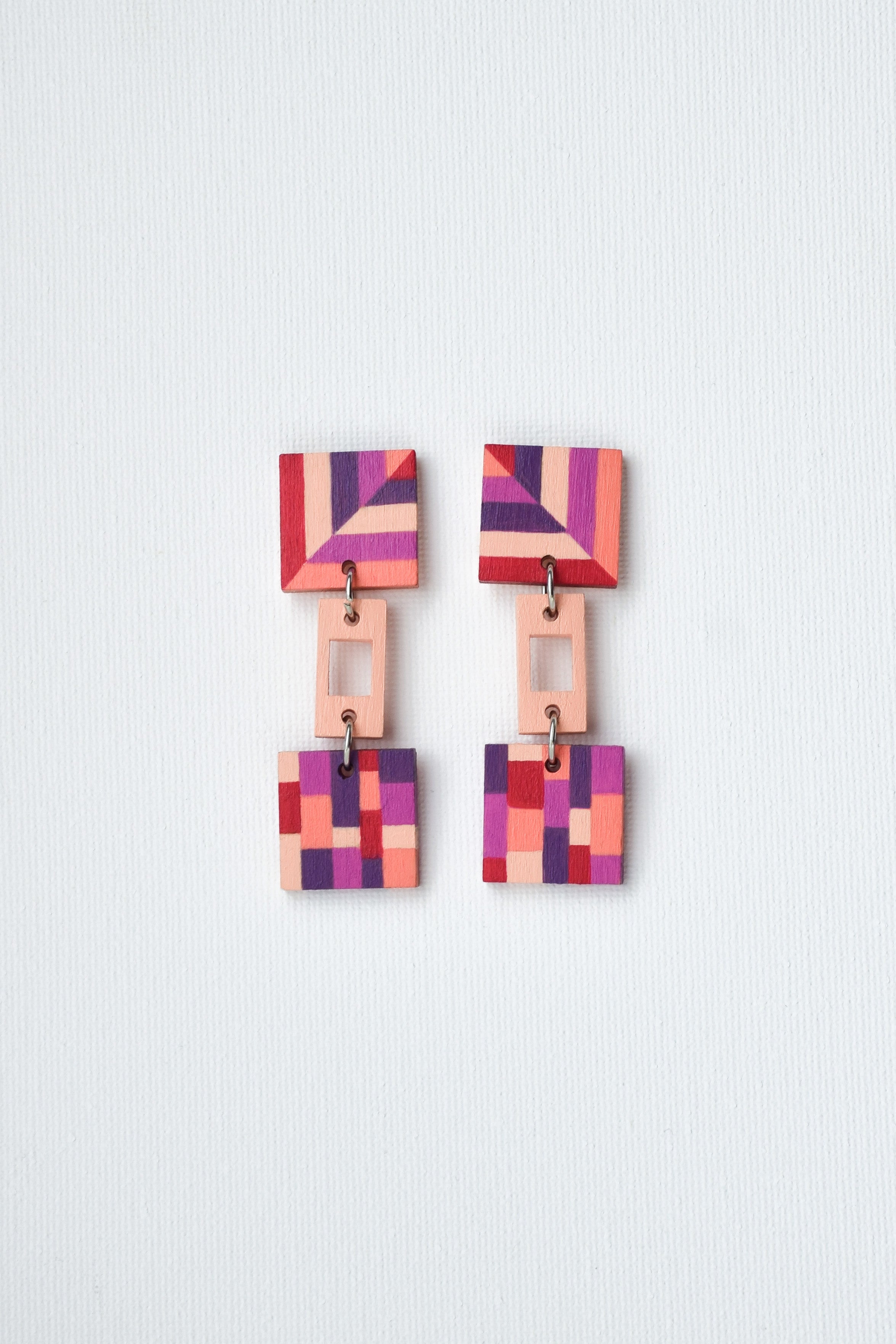 Pair of colorful geometric earrings on a light gray background