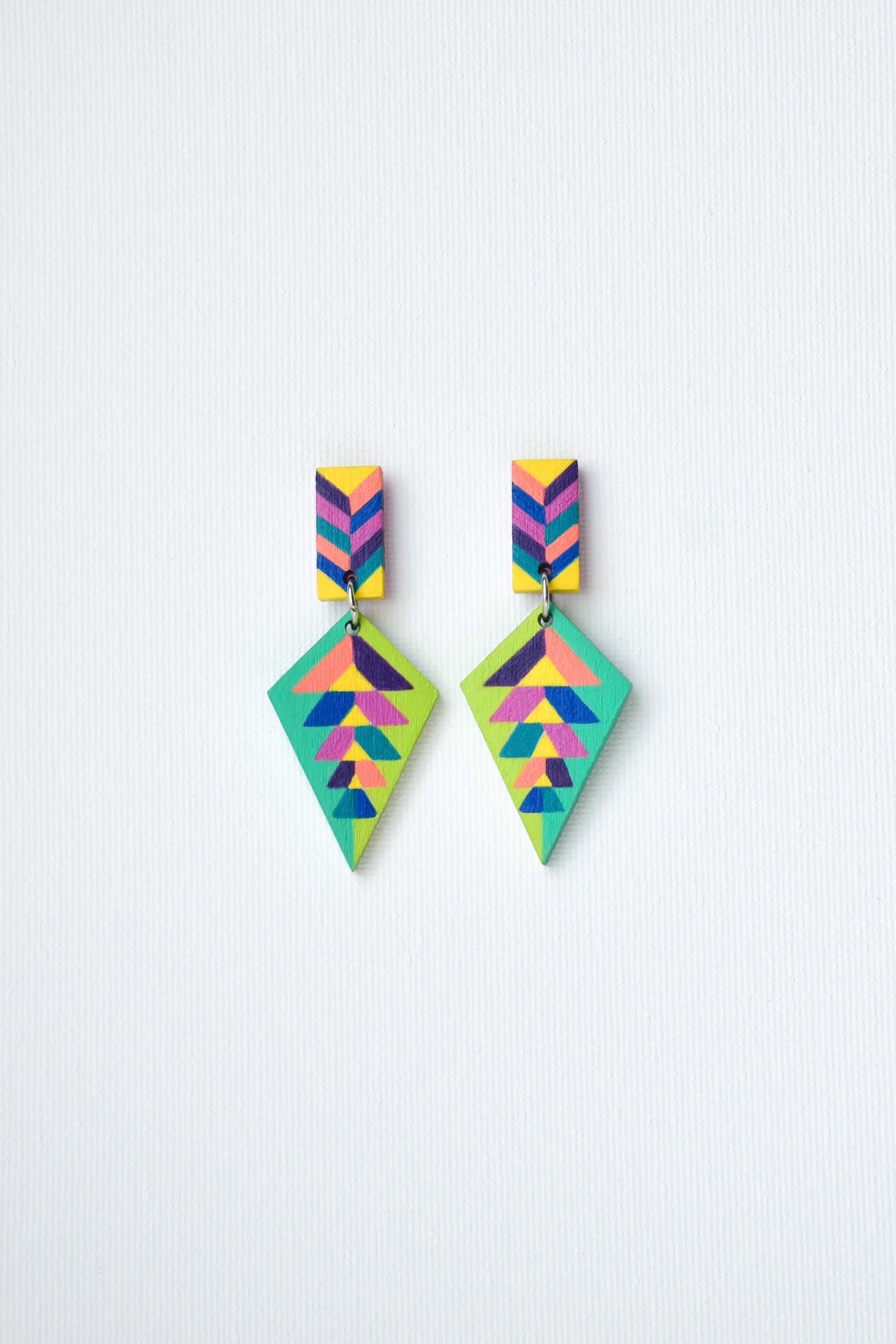 Colorful hand-painted geometric earrings on a light gray background