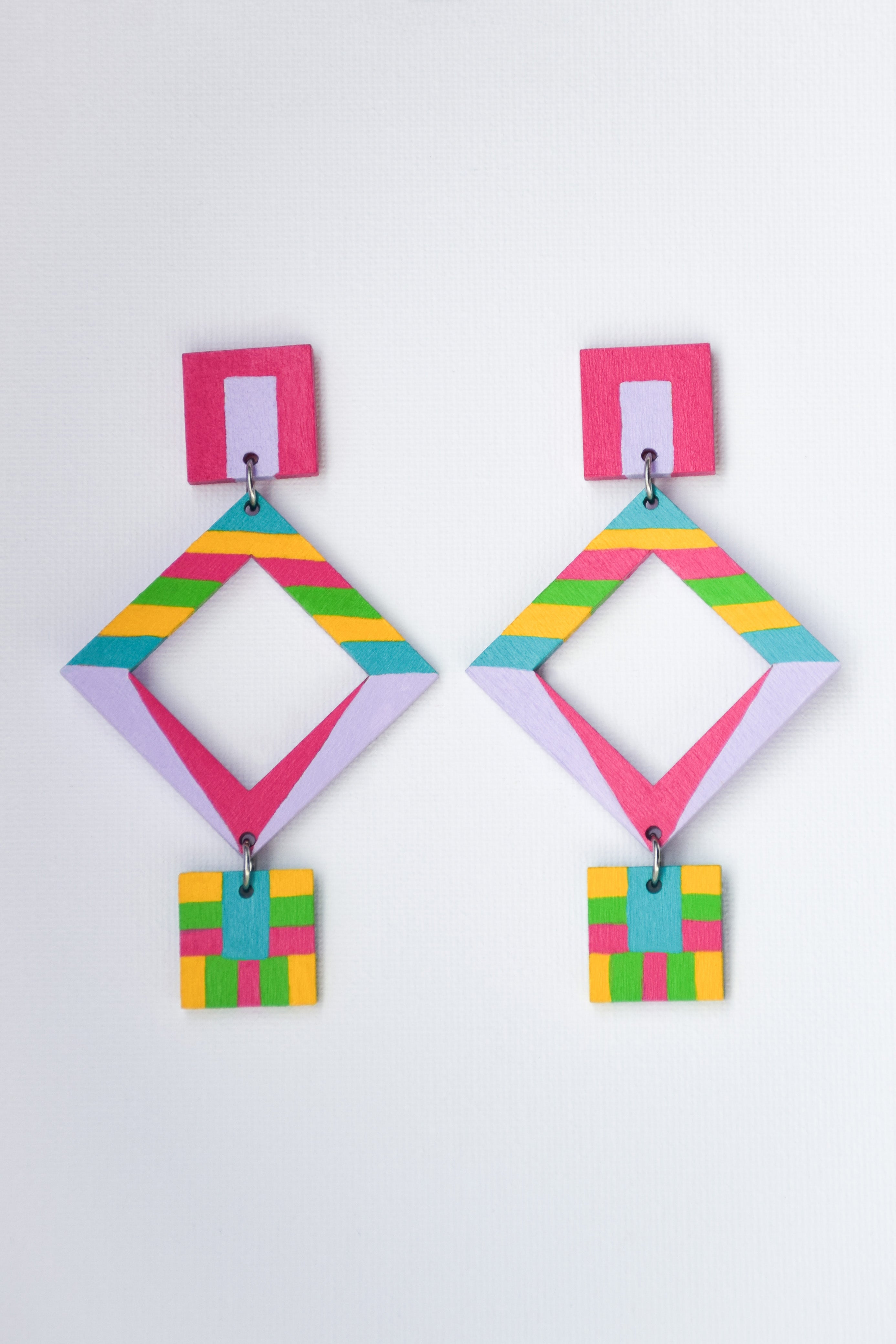 Colorful hand-painted geometric statement earrings on a white background