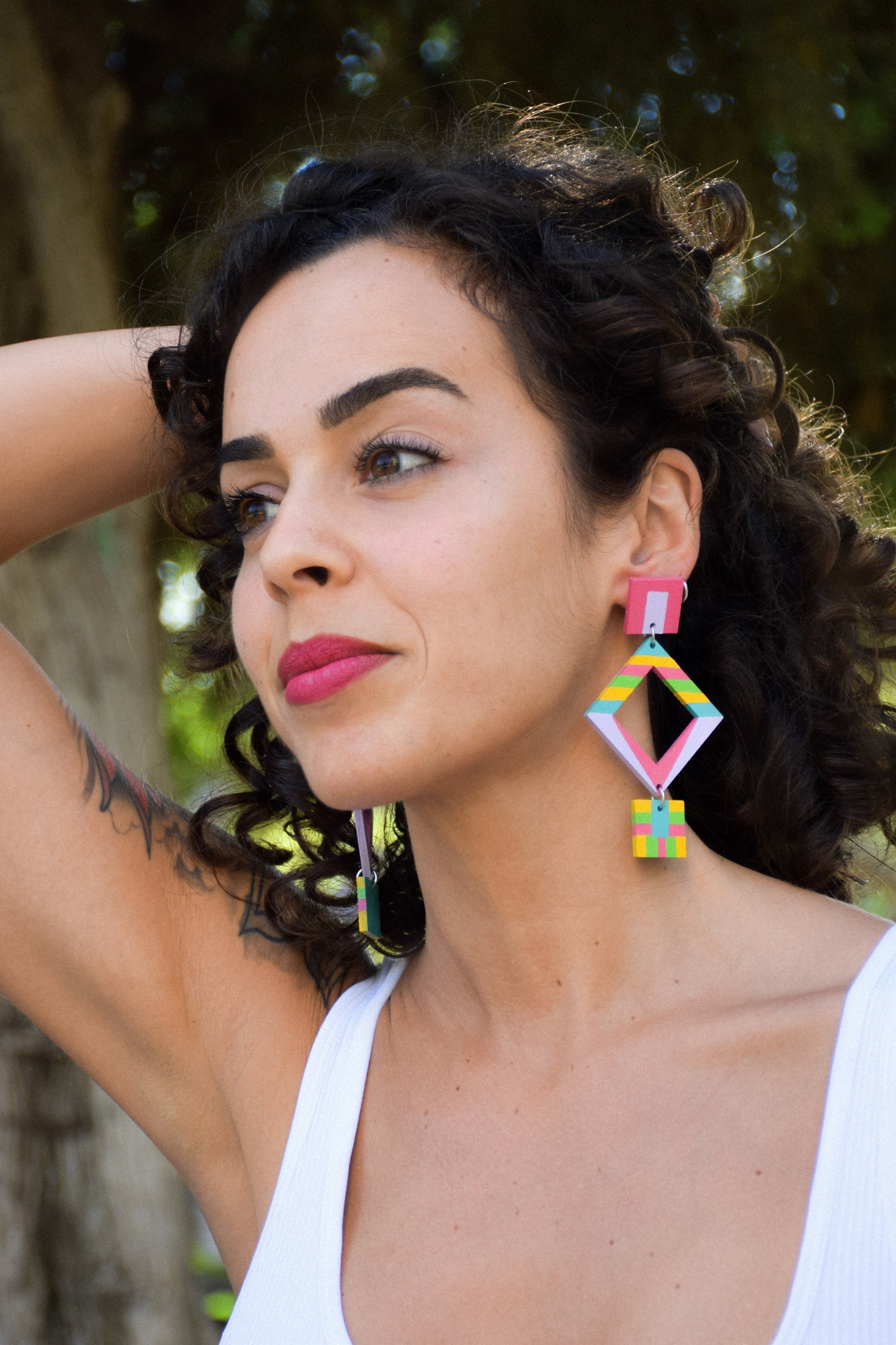 Woman wearing colorful geometric earrings outdoors