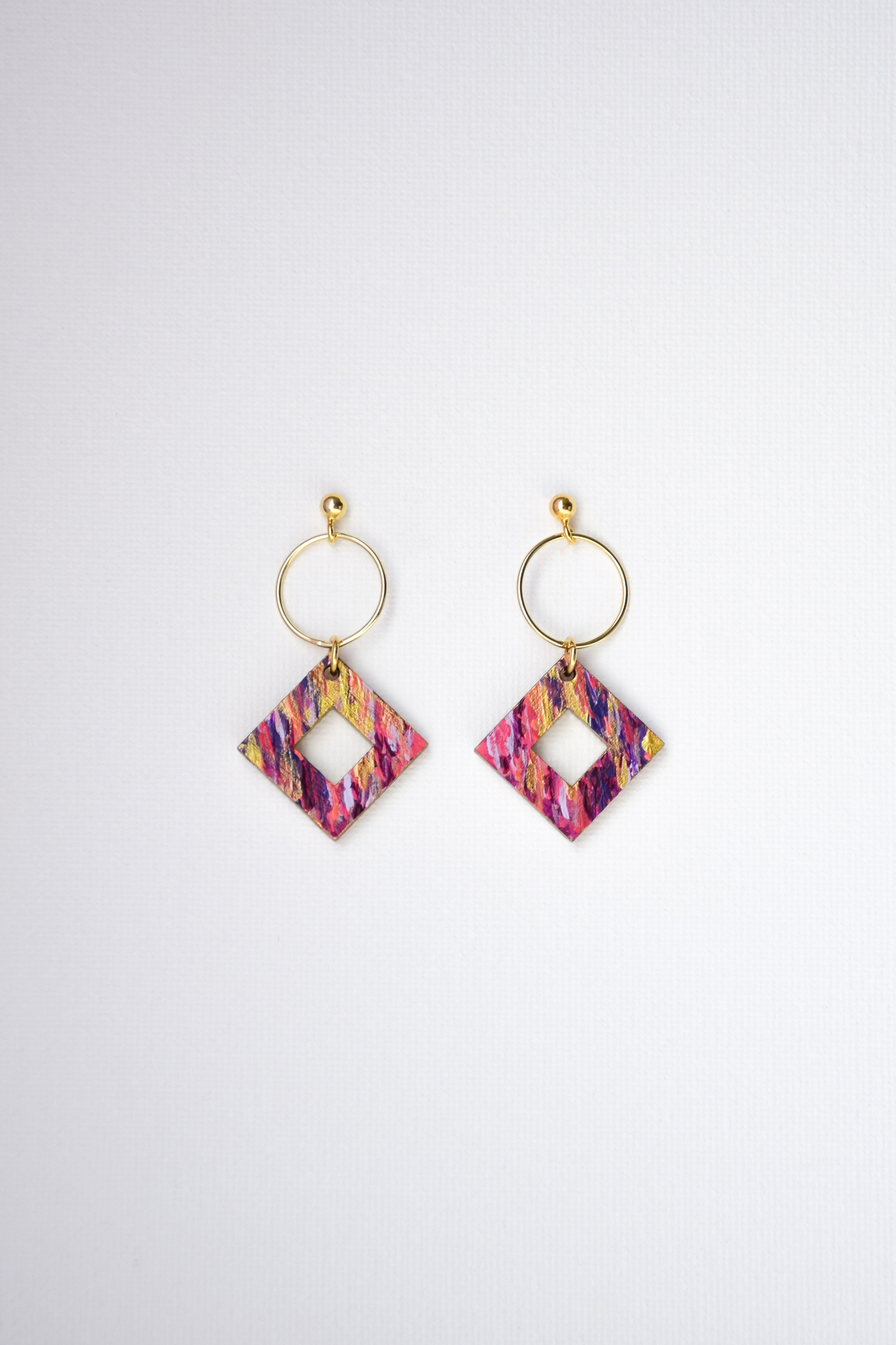 Pair of colorful diamond-shaped earrings with gold-plated silver hoops on a white background