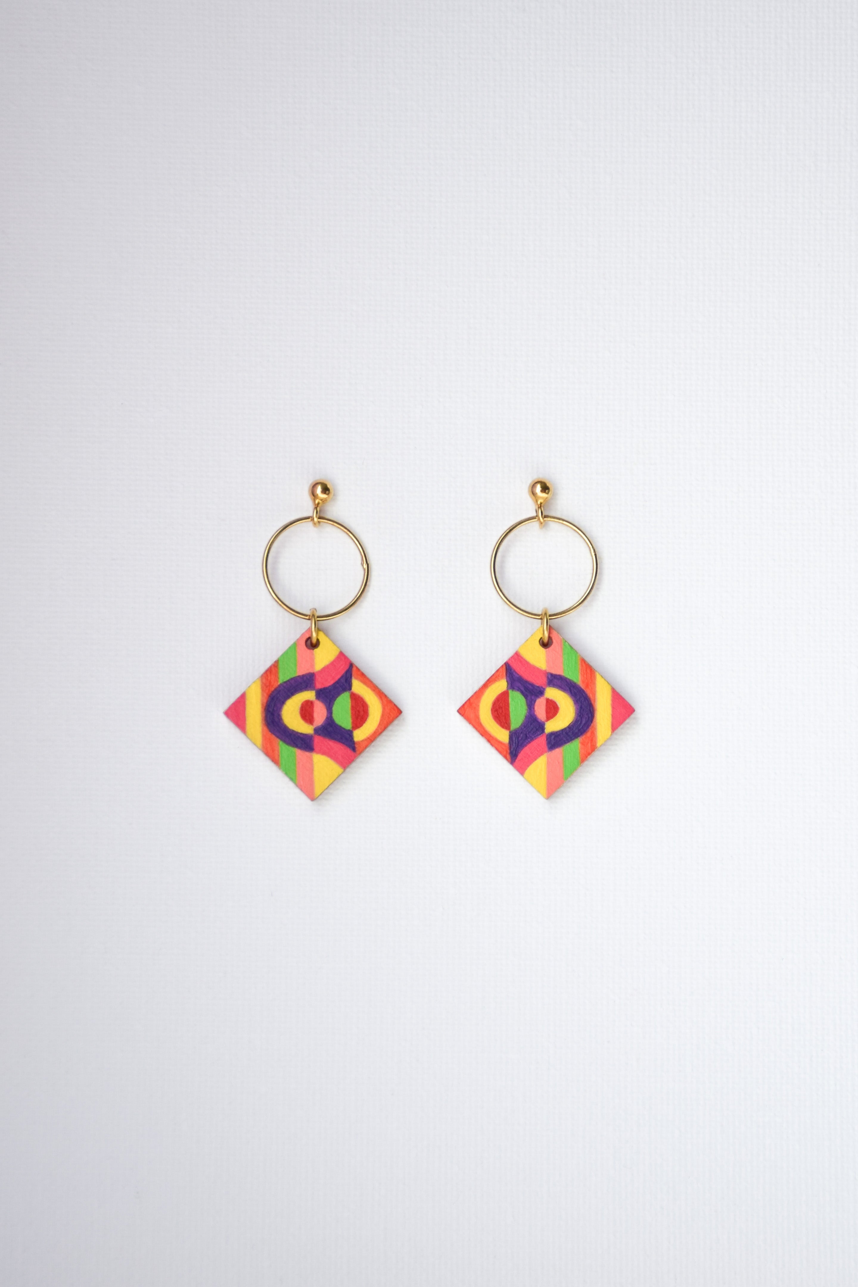 Pair of colorful geometric earrings with gold-plated silver hoops on a white background