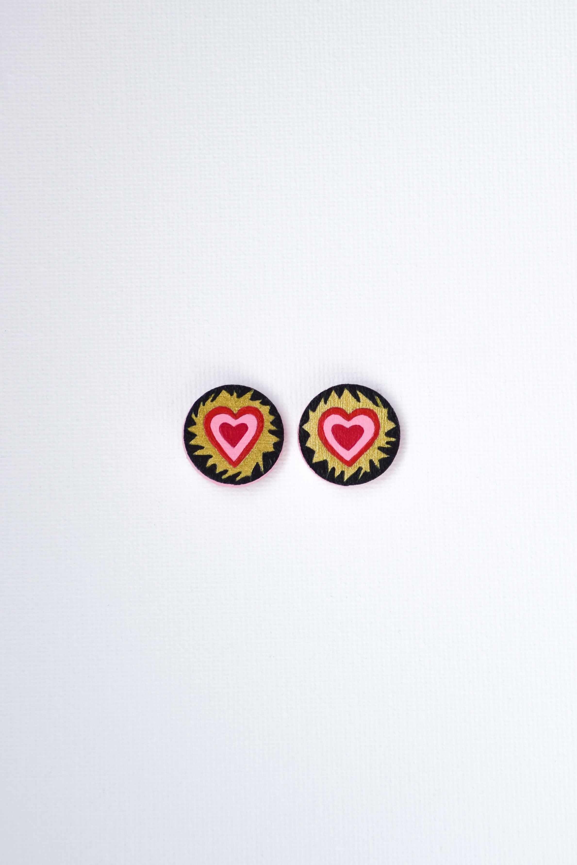 Heart-shaped earrings with colorful designs on a white background