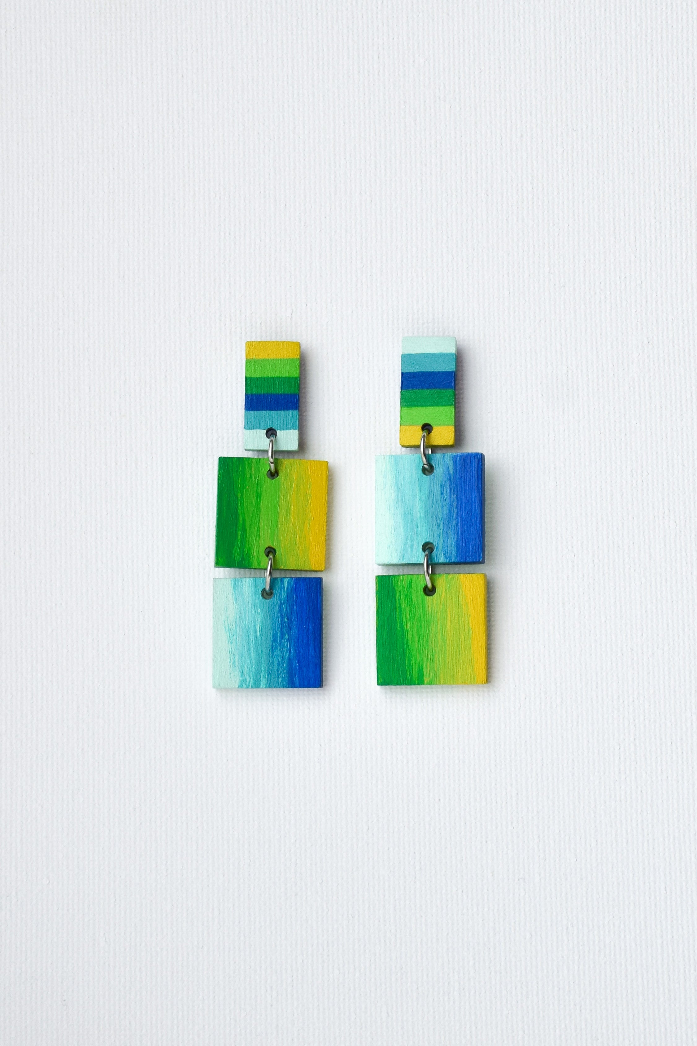 Colorful hand-painted square earrings on a light gray background