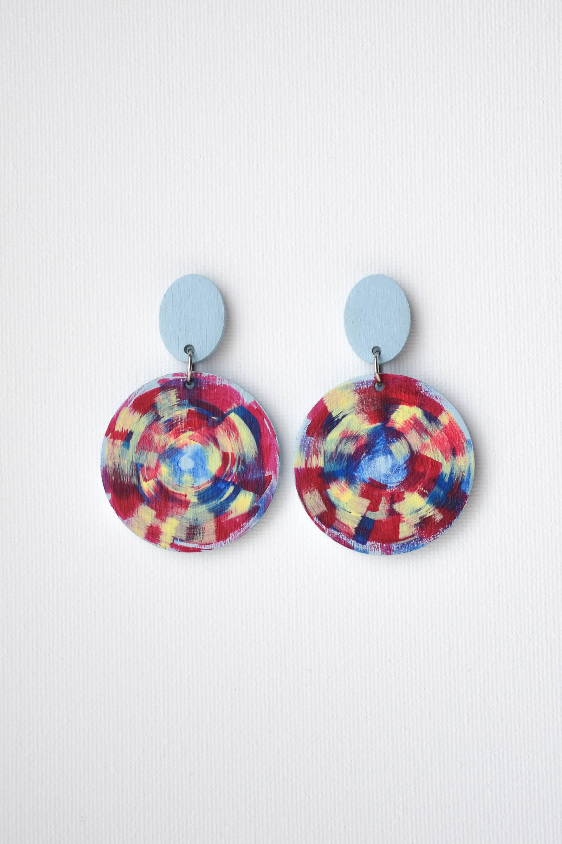 Colorful hand-painted circular earrings on a white background