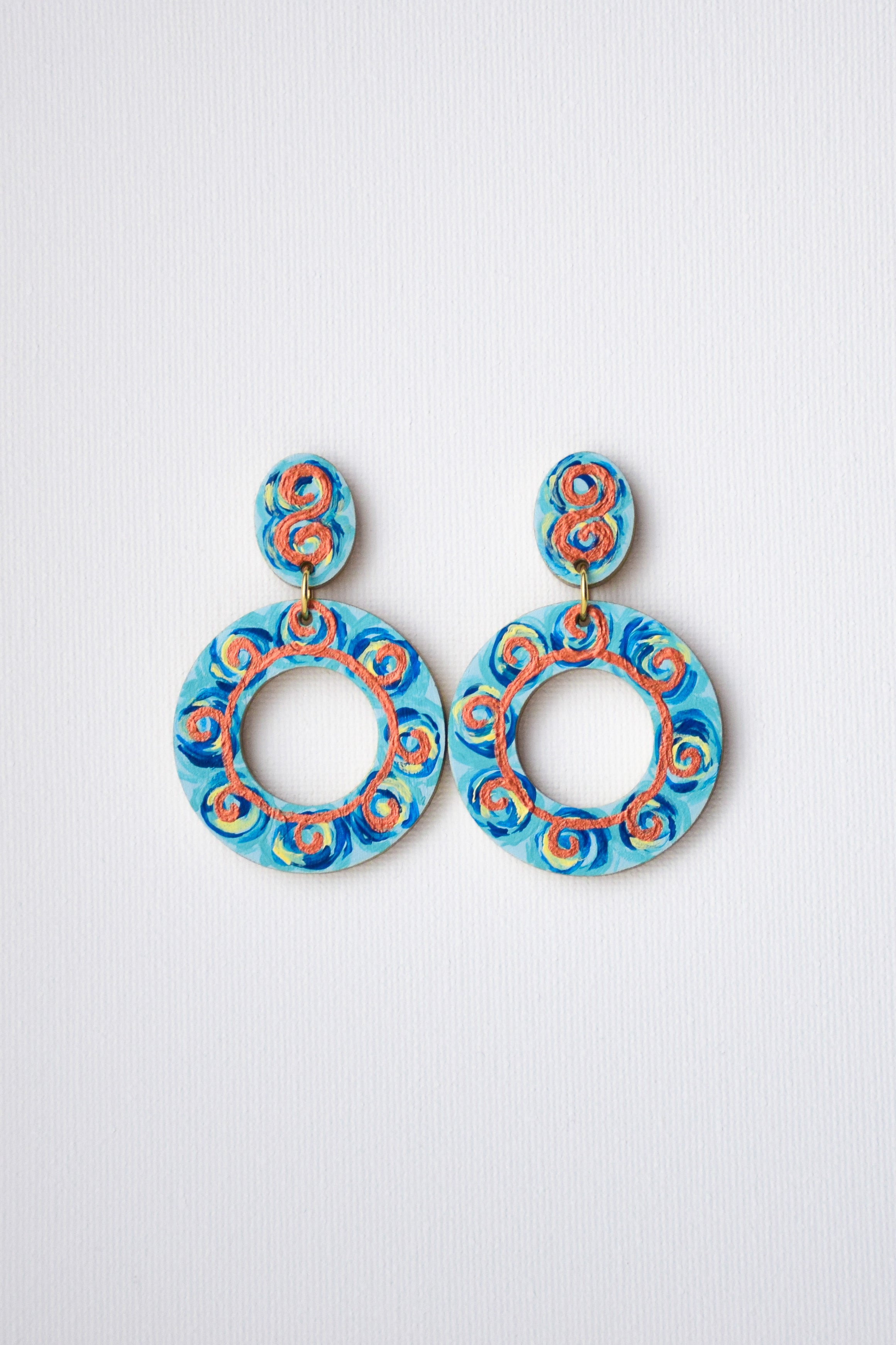 Pair of blue and orange earrings on a light gray background