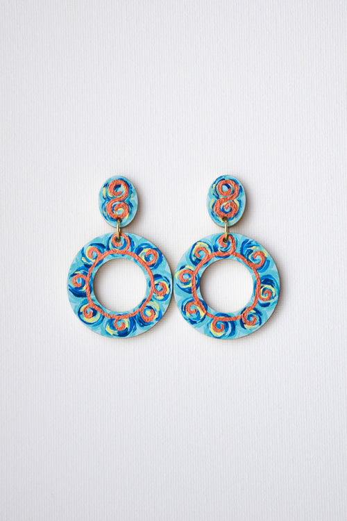 Pair of blue and orange earrings on a light gray background