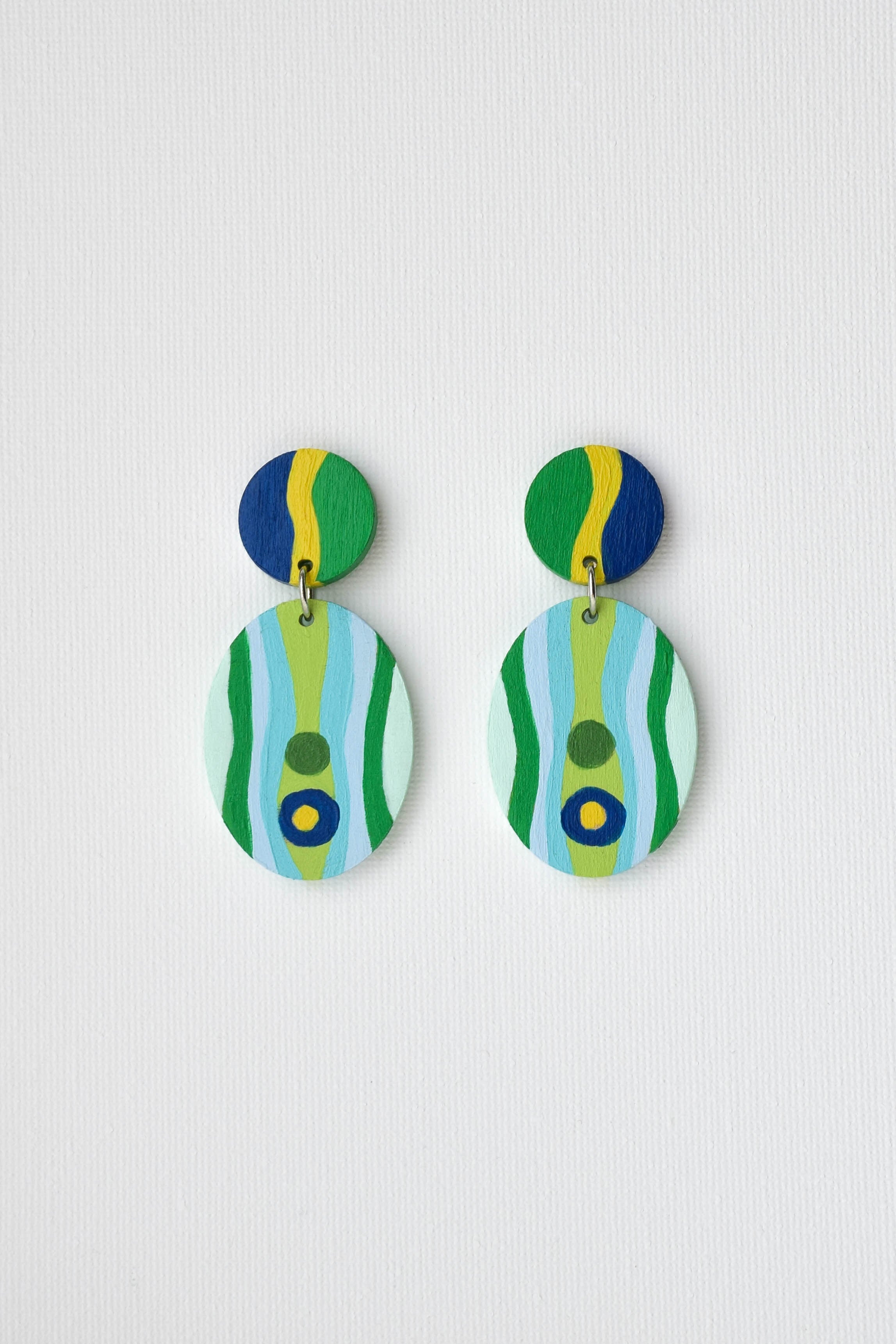Pair of hand-painted colorful earrings with striped design on a light gray background