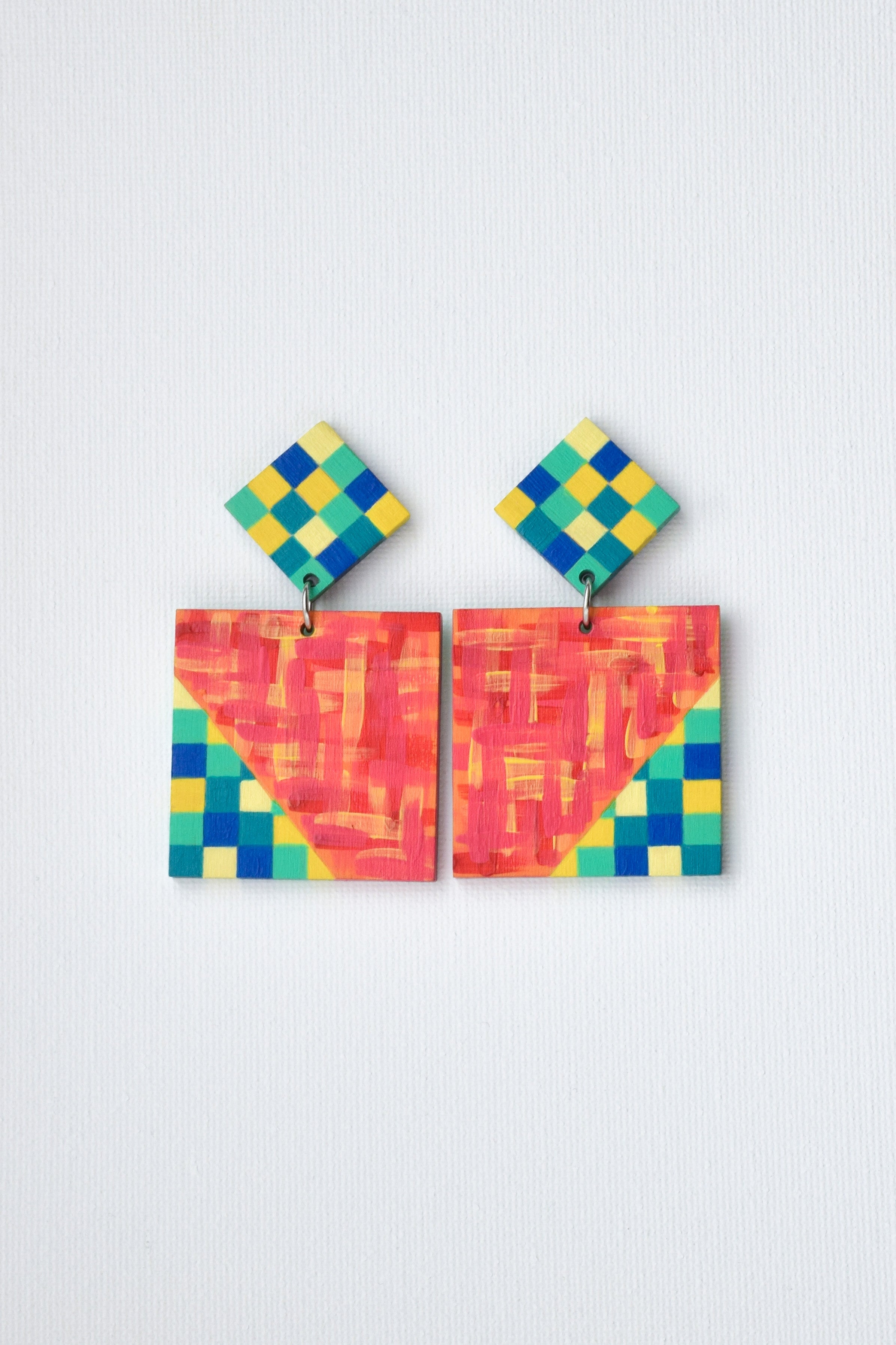 Colorful geometric patterned earrings on a light gray background