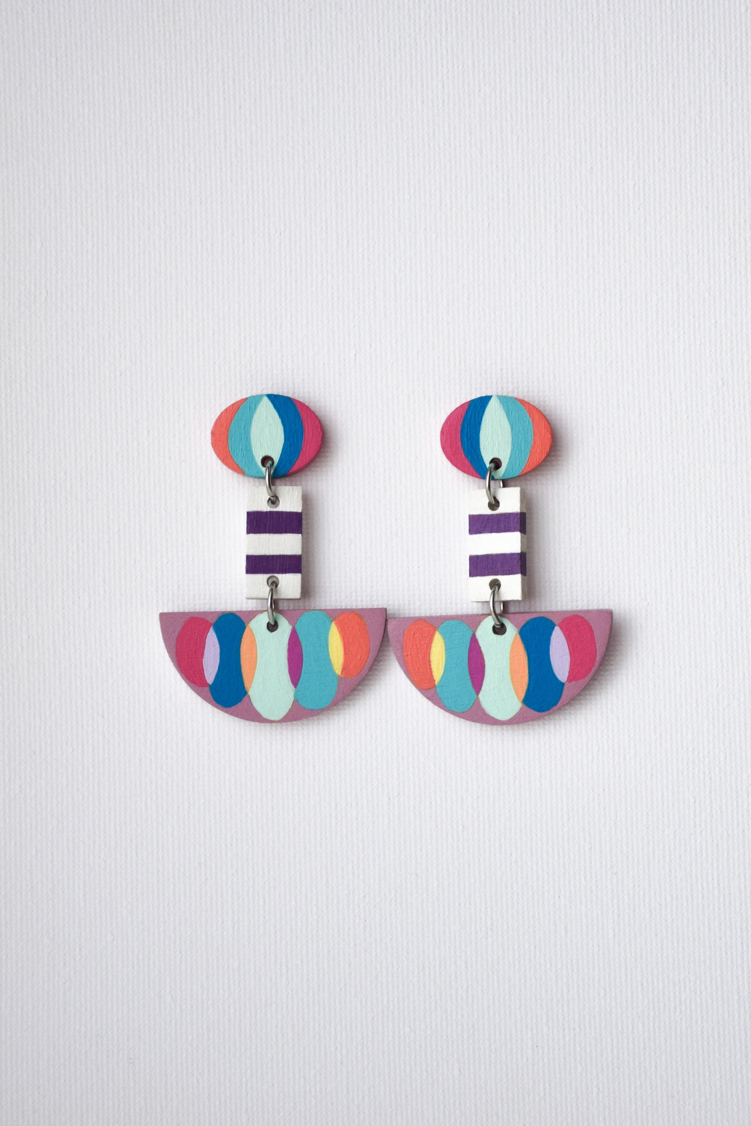 Colorful hand-painted earrings with geometric design on a light gray background
