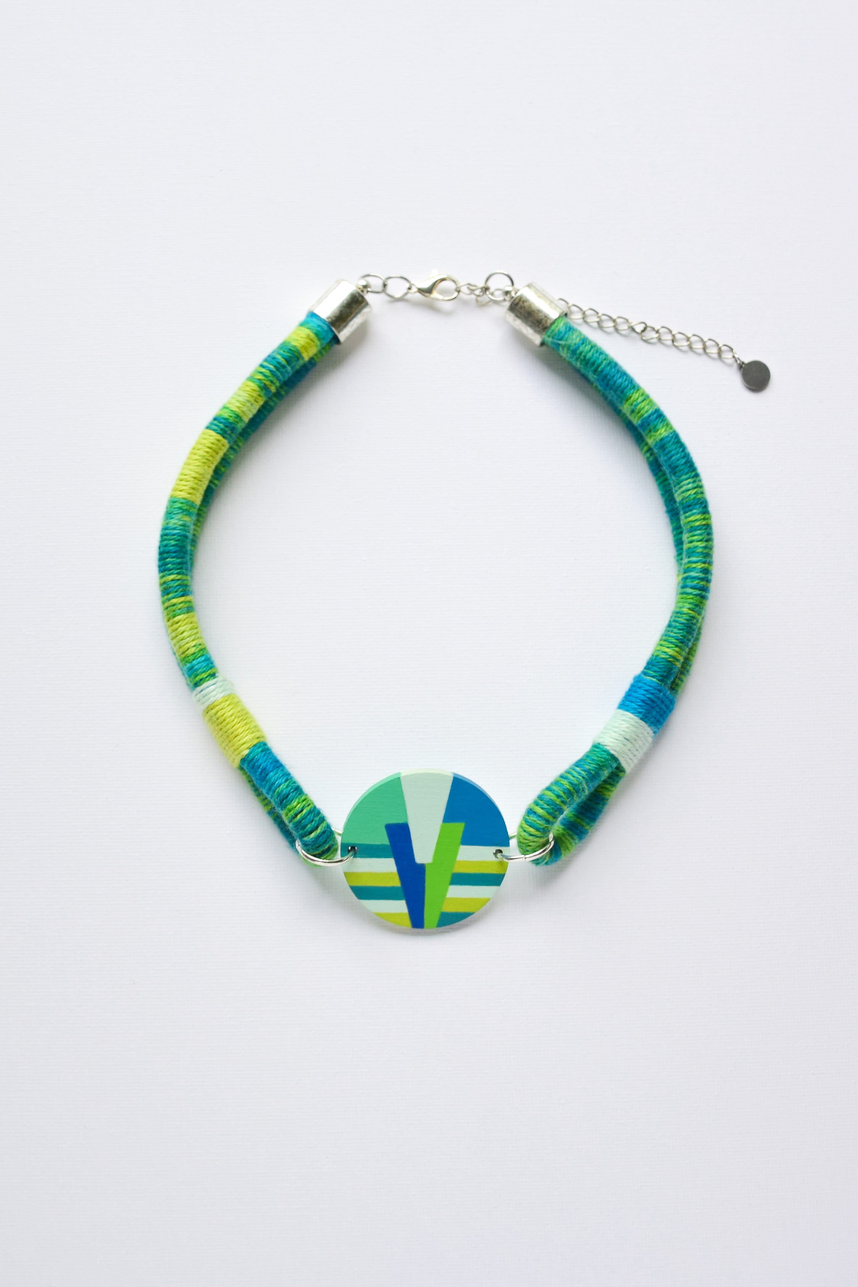 Choker necklace with a colorful pendant in blue and green tones on a white background