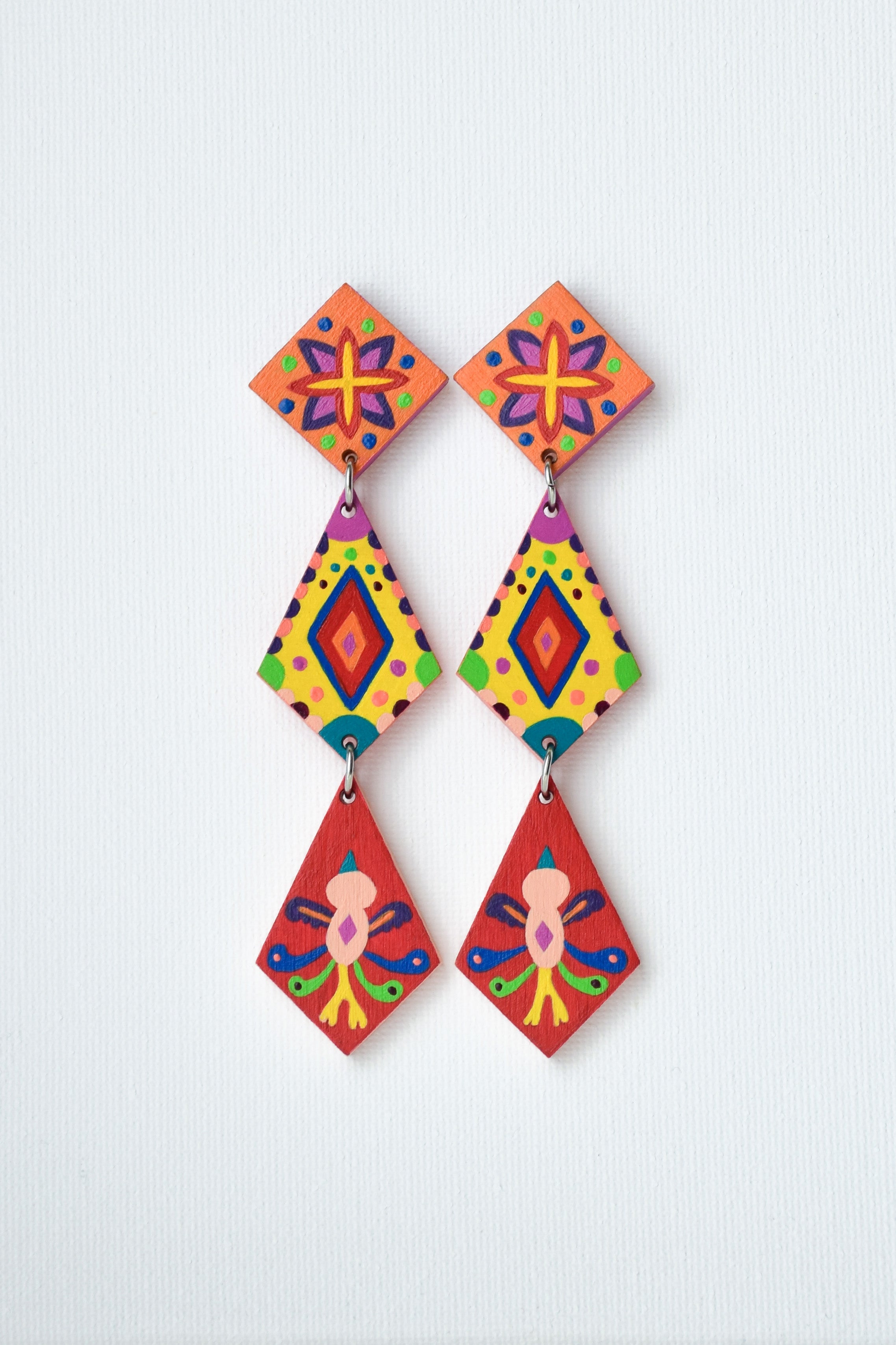 Colorful hand-painted Mexican geometric earrings on a light gray background