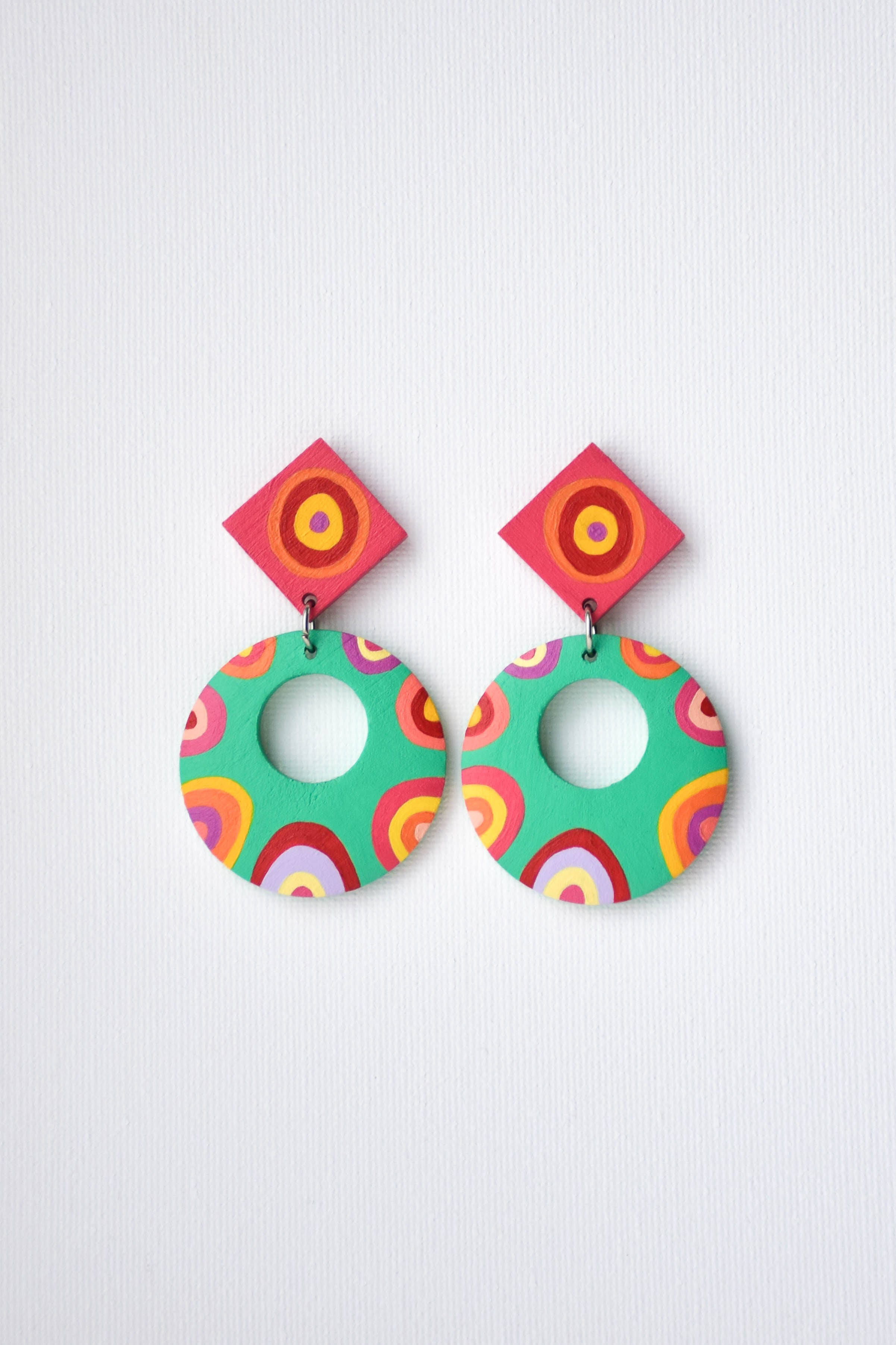 Colorful hand-painted circular earrings on a white background