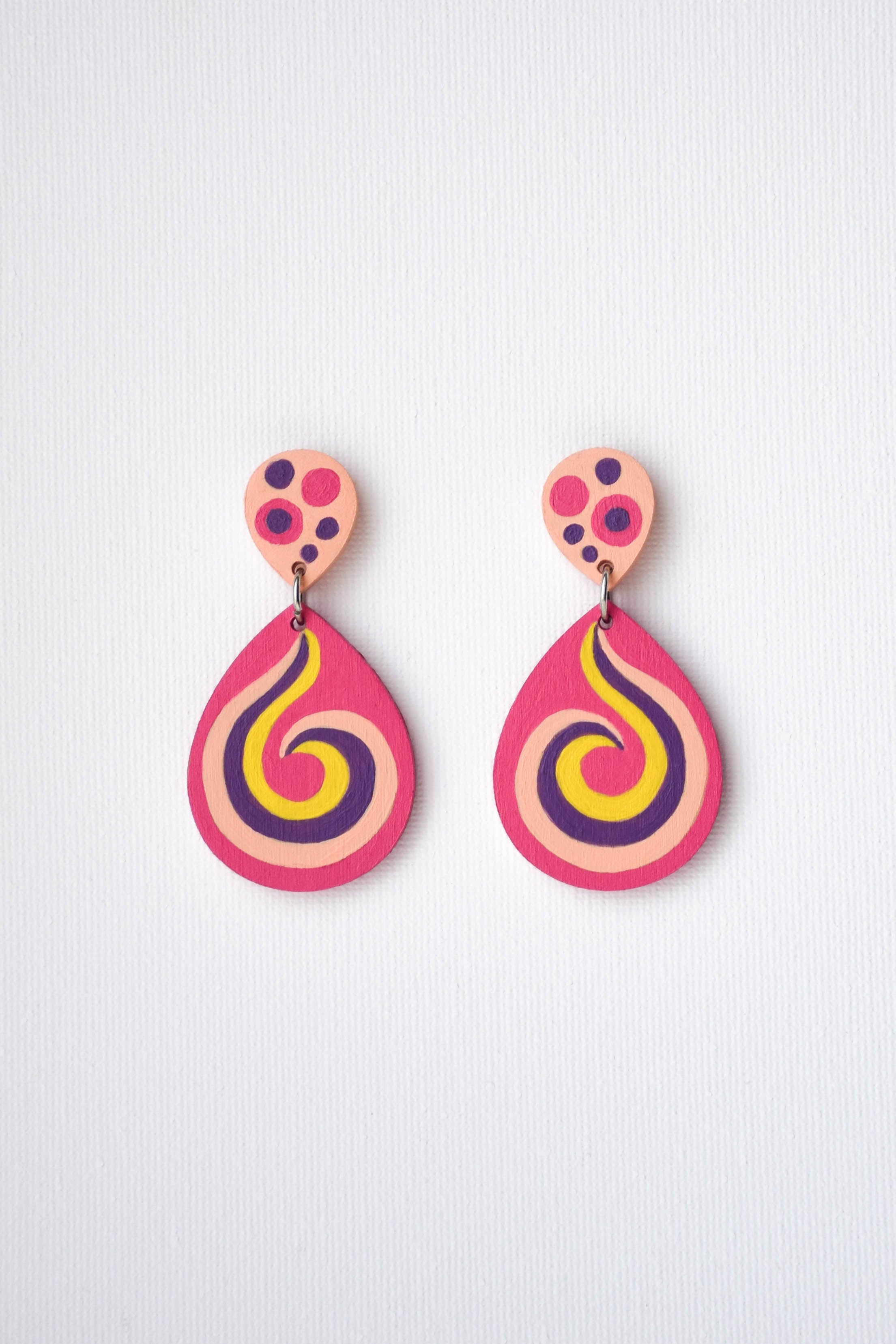 Colorful spiral-shaped earrings on a light gray background