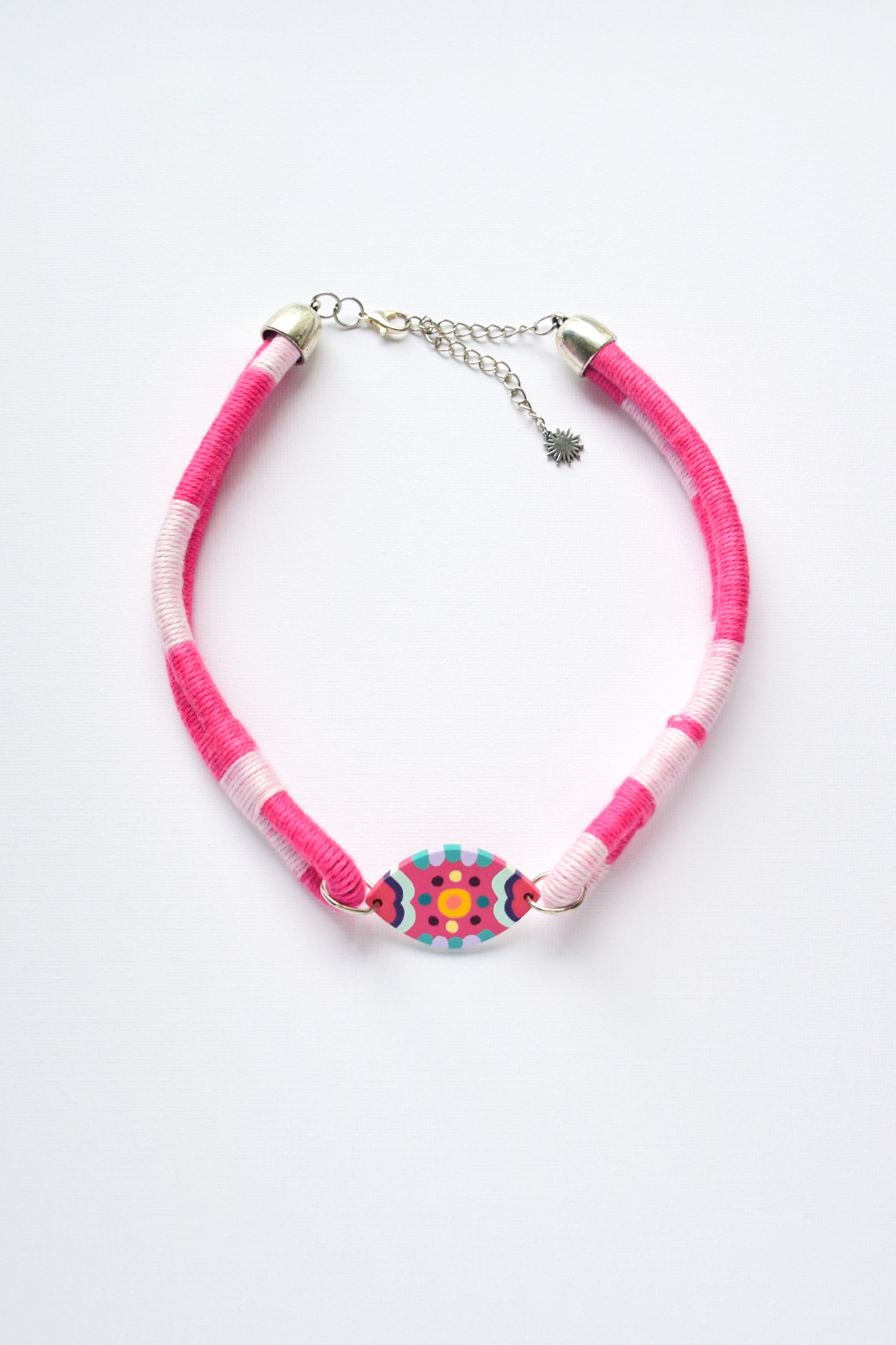 Hand-painted choker necklace featuring a decorative geometric pendant and playful colour accents.