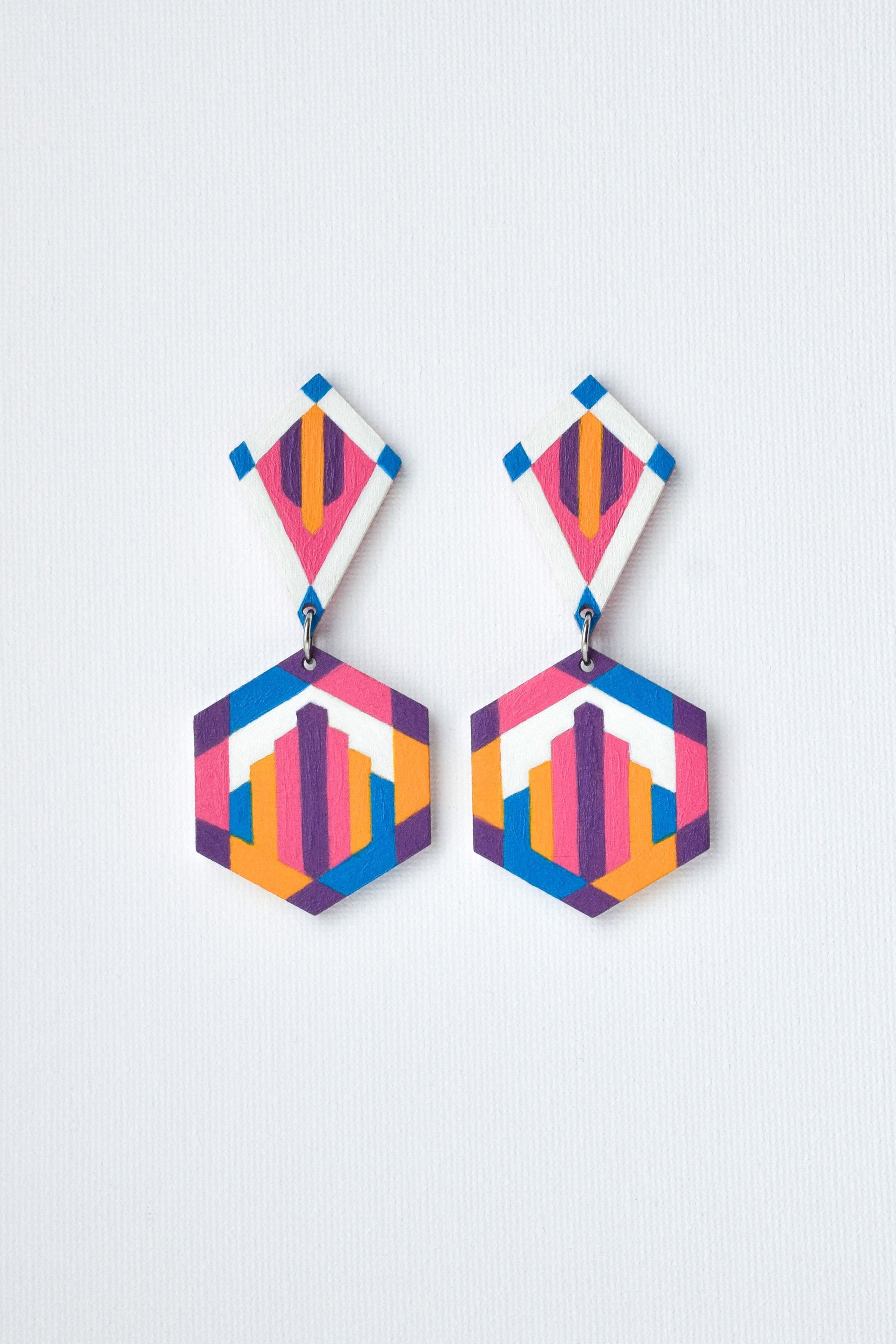 Colorful geometric earrings on a light gray background