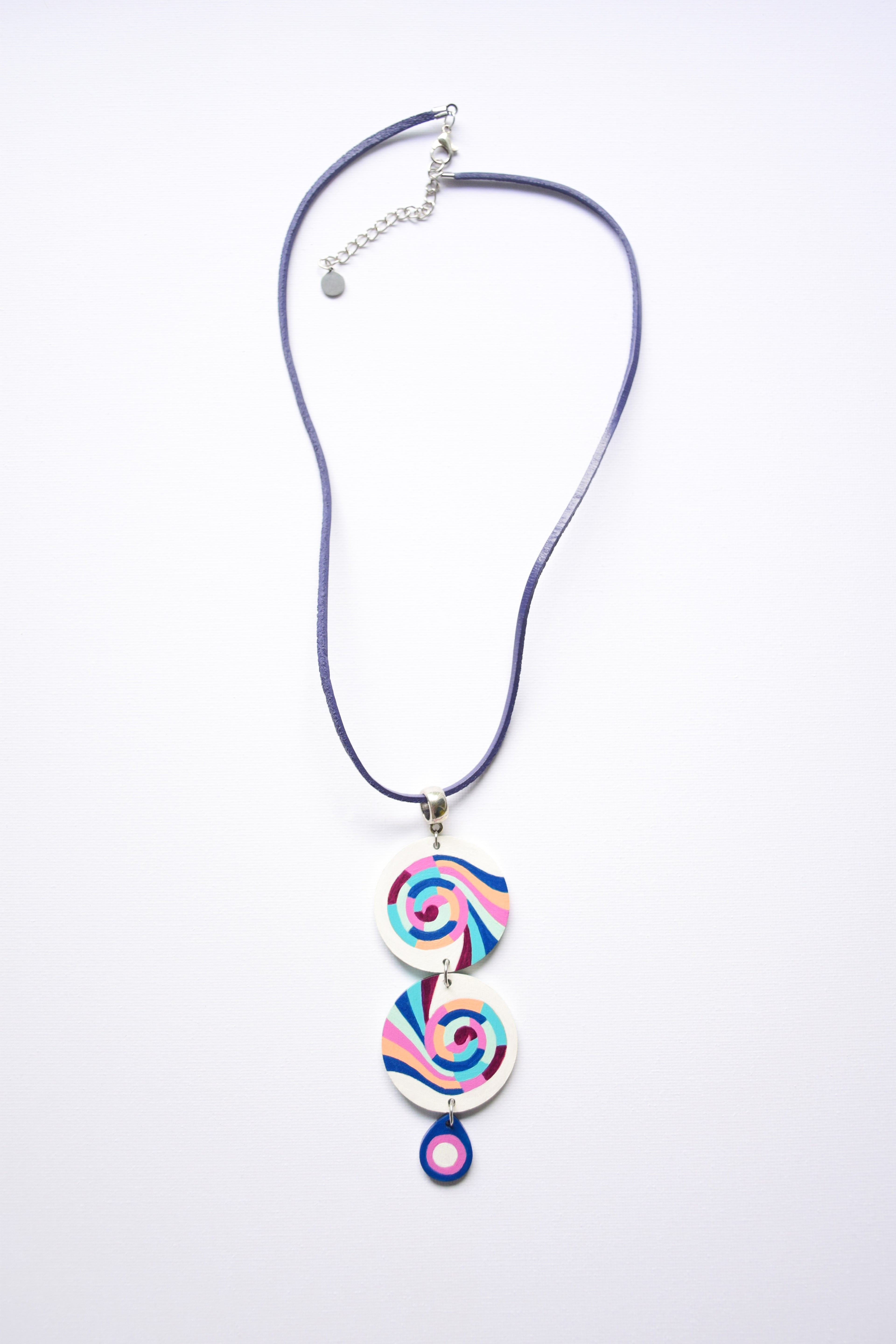 Leather cord necklace with a colorful hand-painted spiral pendant on a white background