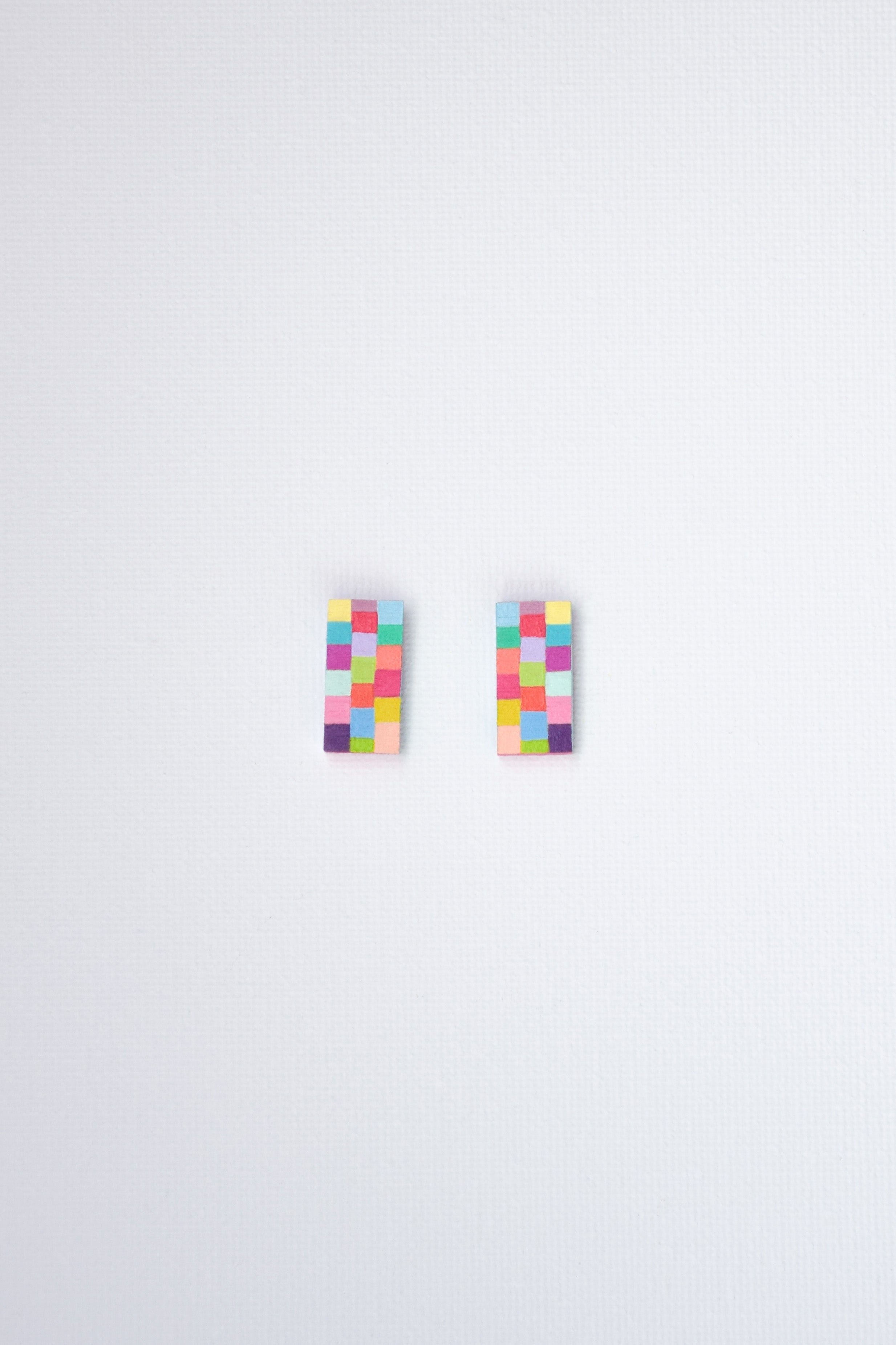 Pair of colorful checkered earrings on a white background