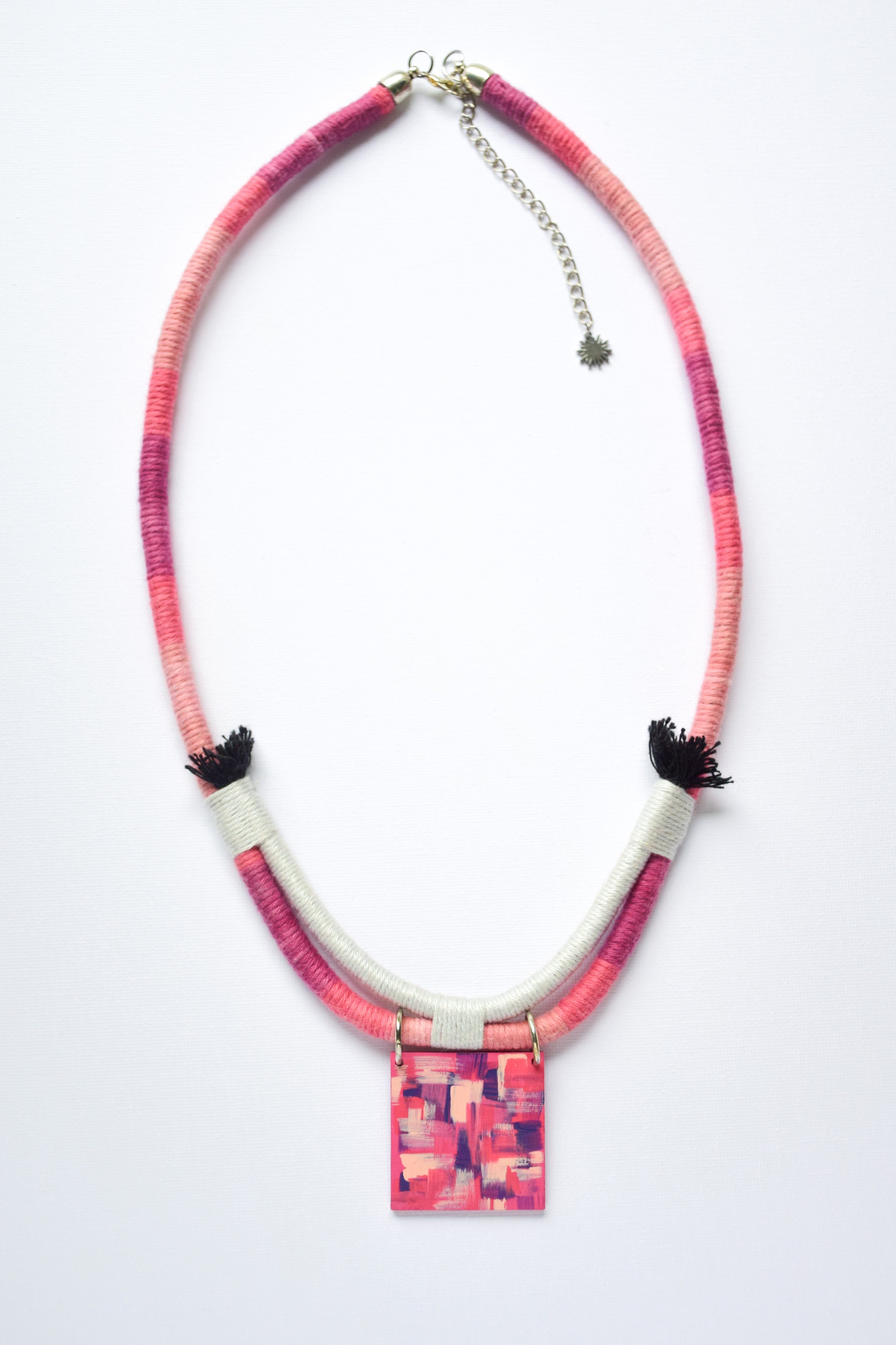 Necklace with pink and purple patterned pendant on a white background