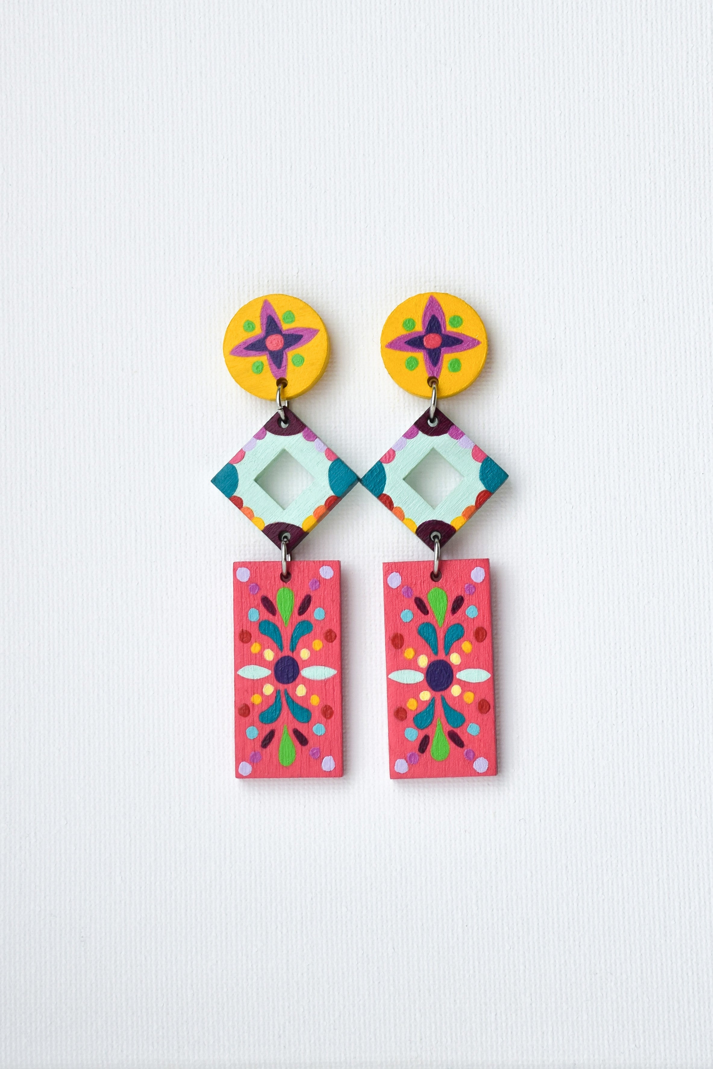 Colorful hand-painted Mexican geometric earrings on a light gray background