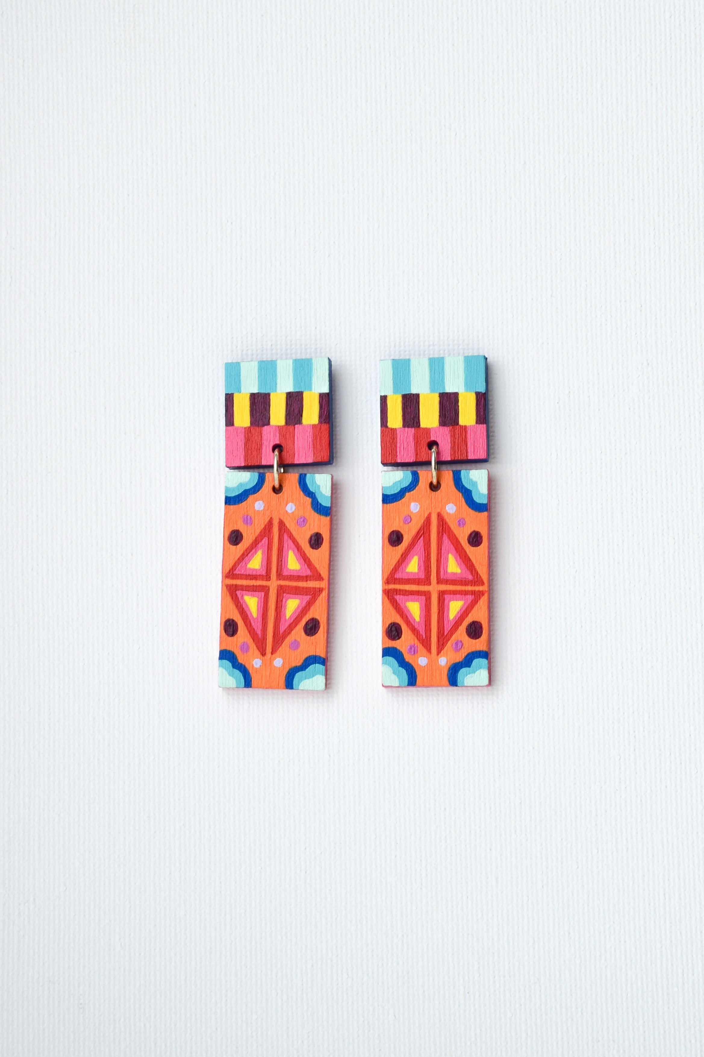 Pair of colorful Mexican geometric earrings on a light gray background