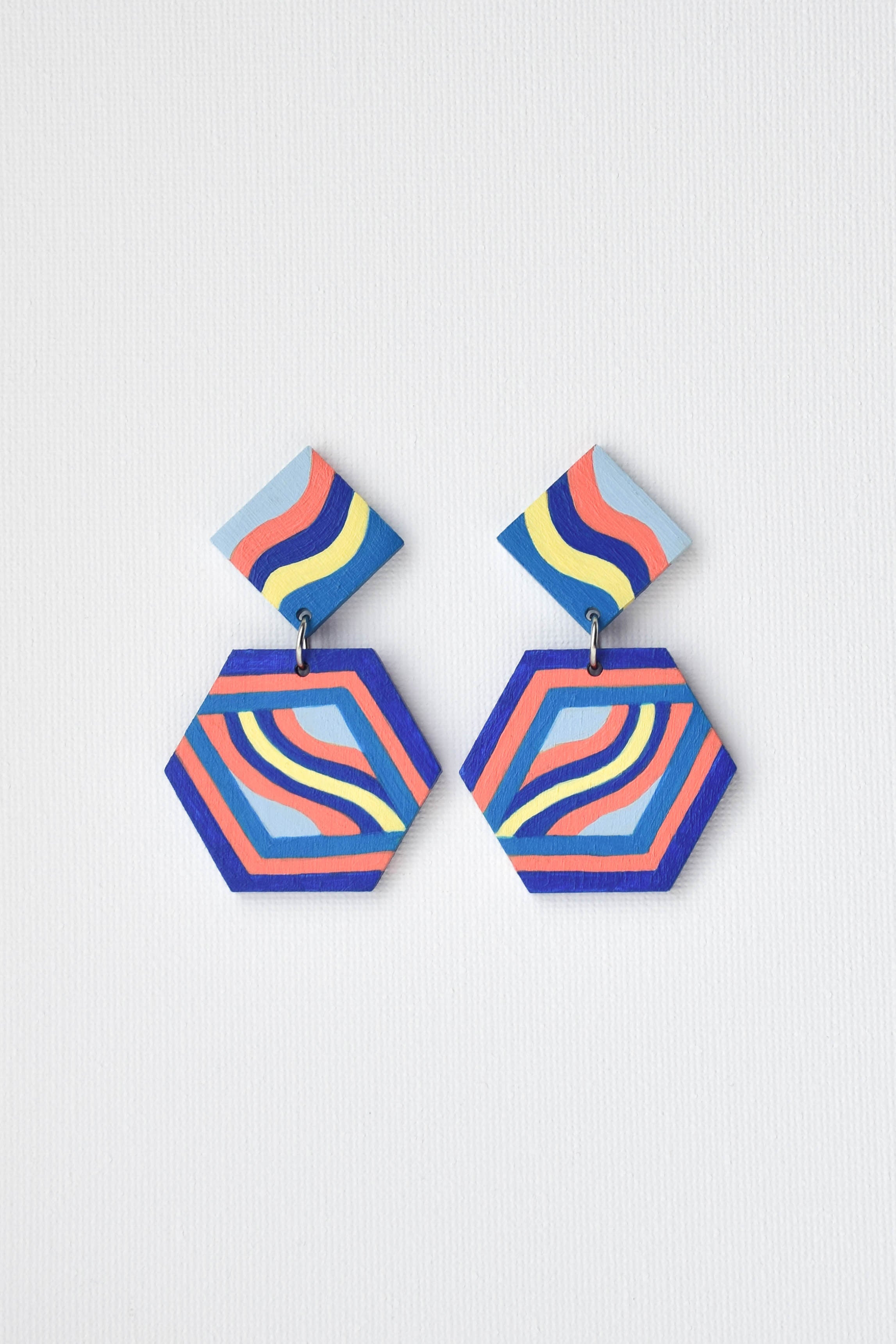 Colorful hexagonal earrings on a light gray background
