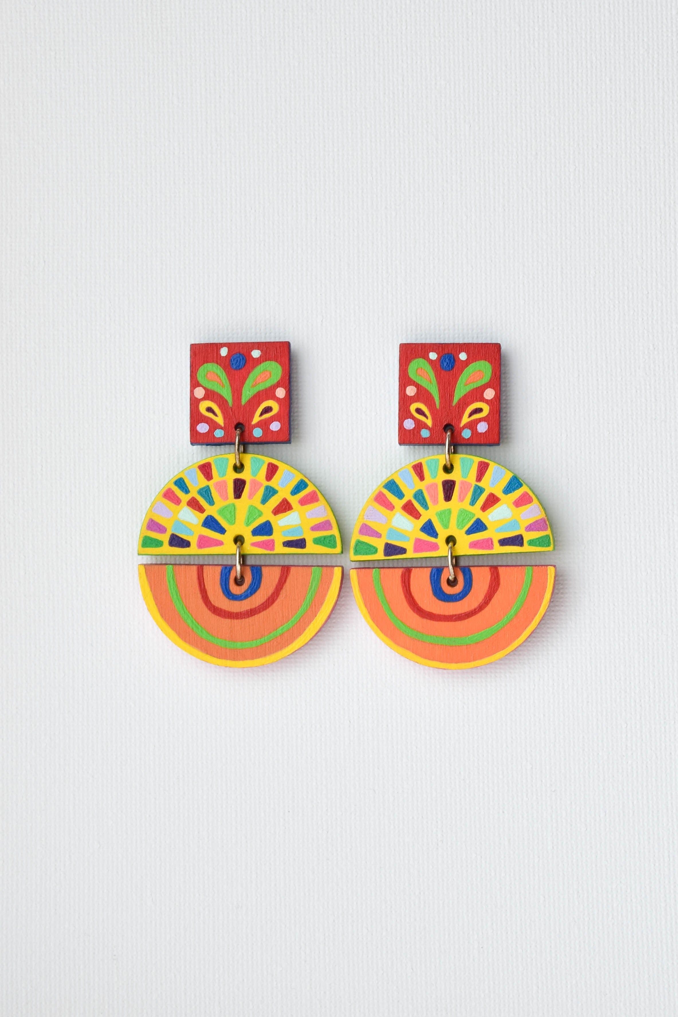 Colorful hand-painted circular earrings on a light gray background