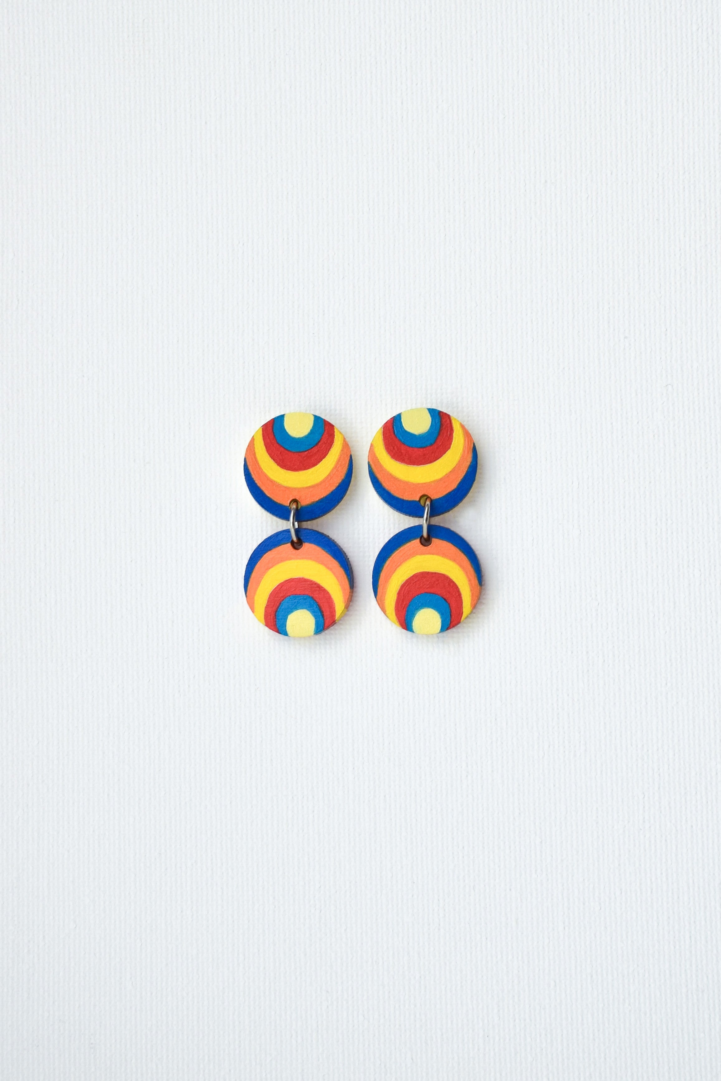 Colorful circular earrings on a light gray background