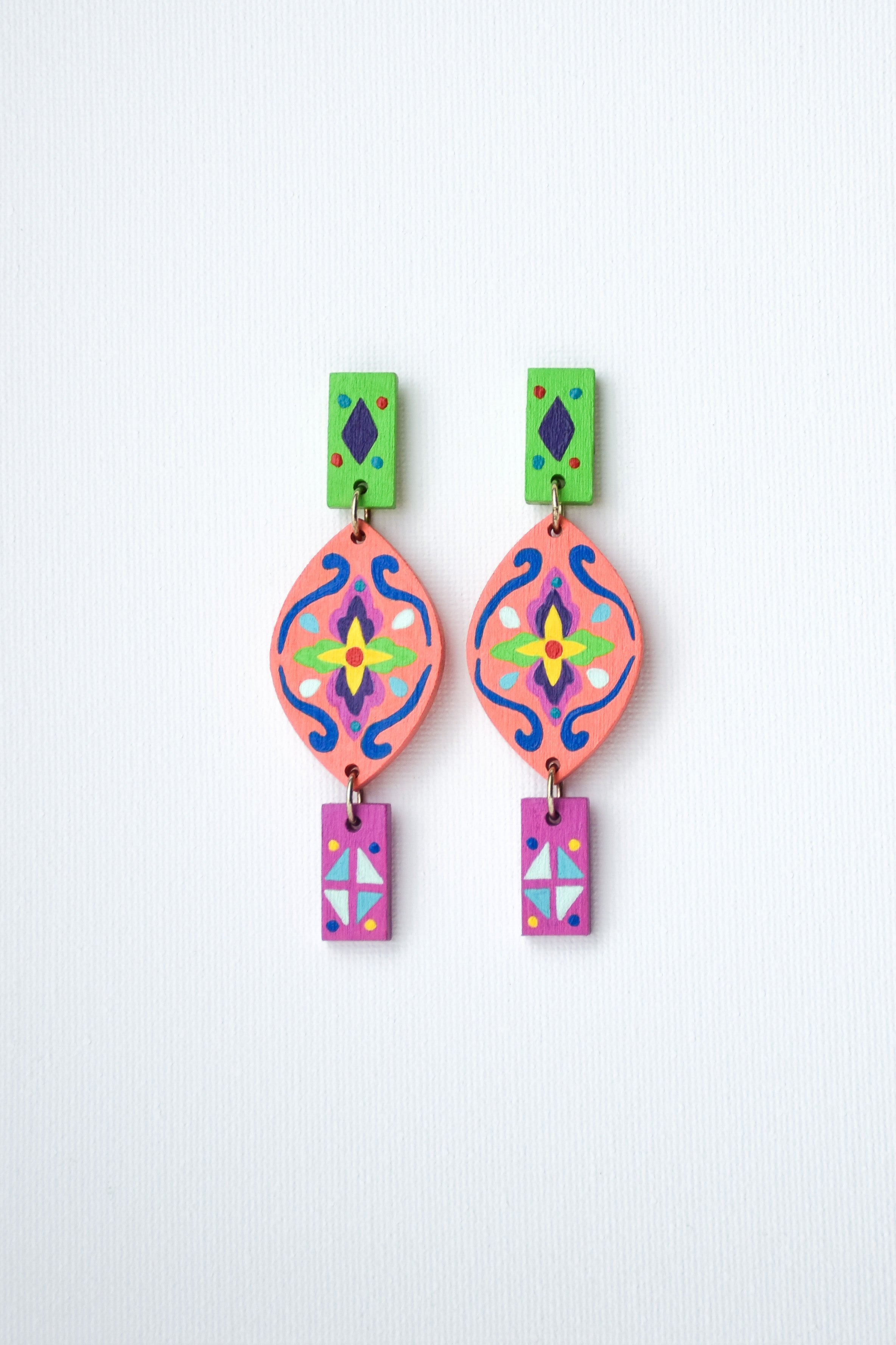 Colorful hand-painted Mexican earrings with geometric designs on a white background