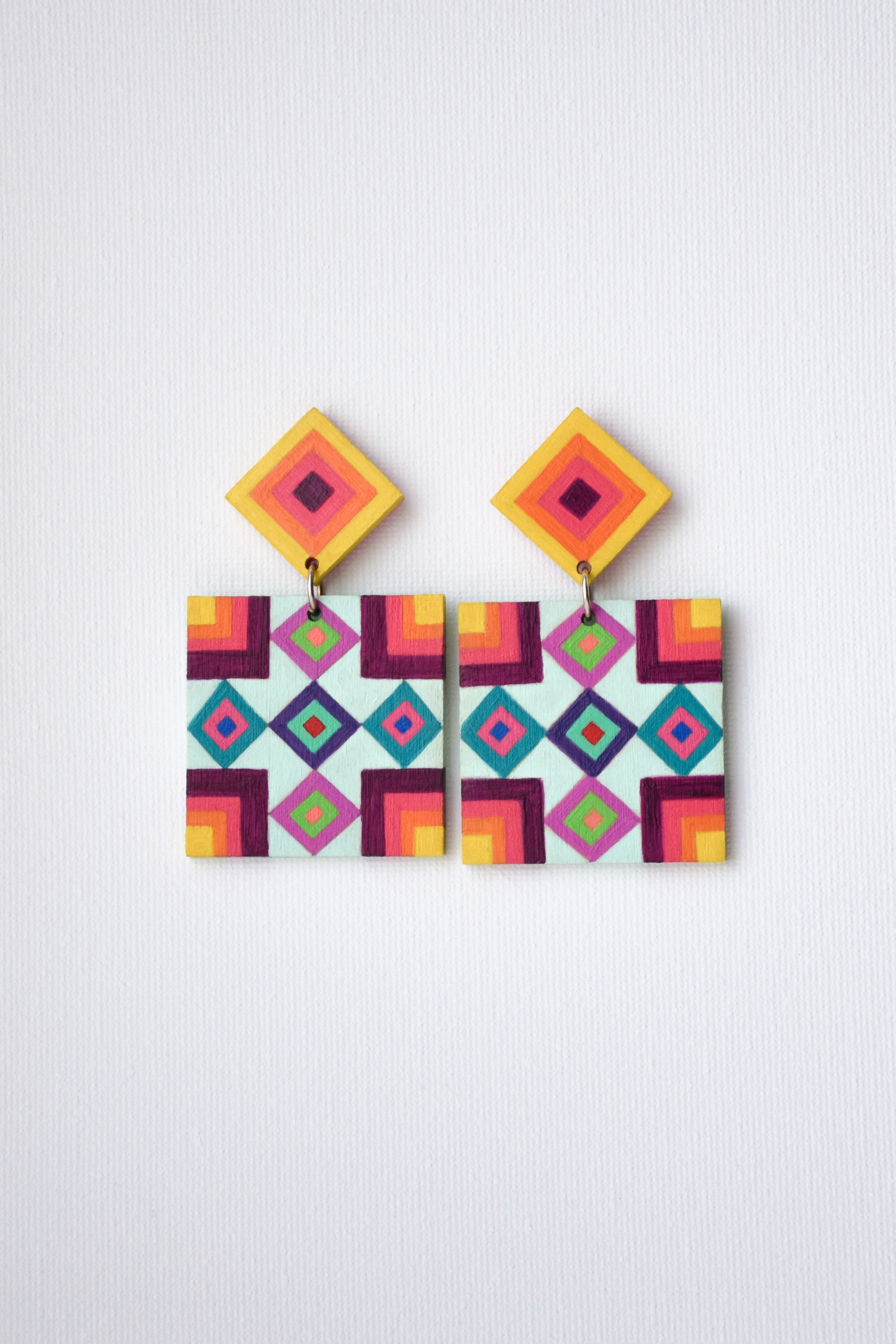 Colorful geometric patterned earrings on a white background