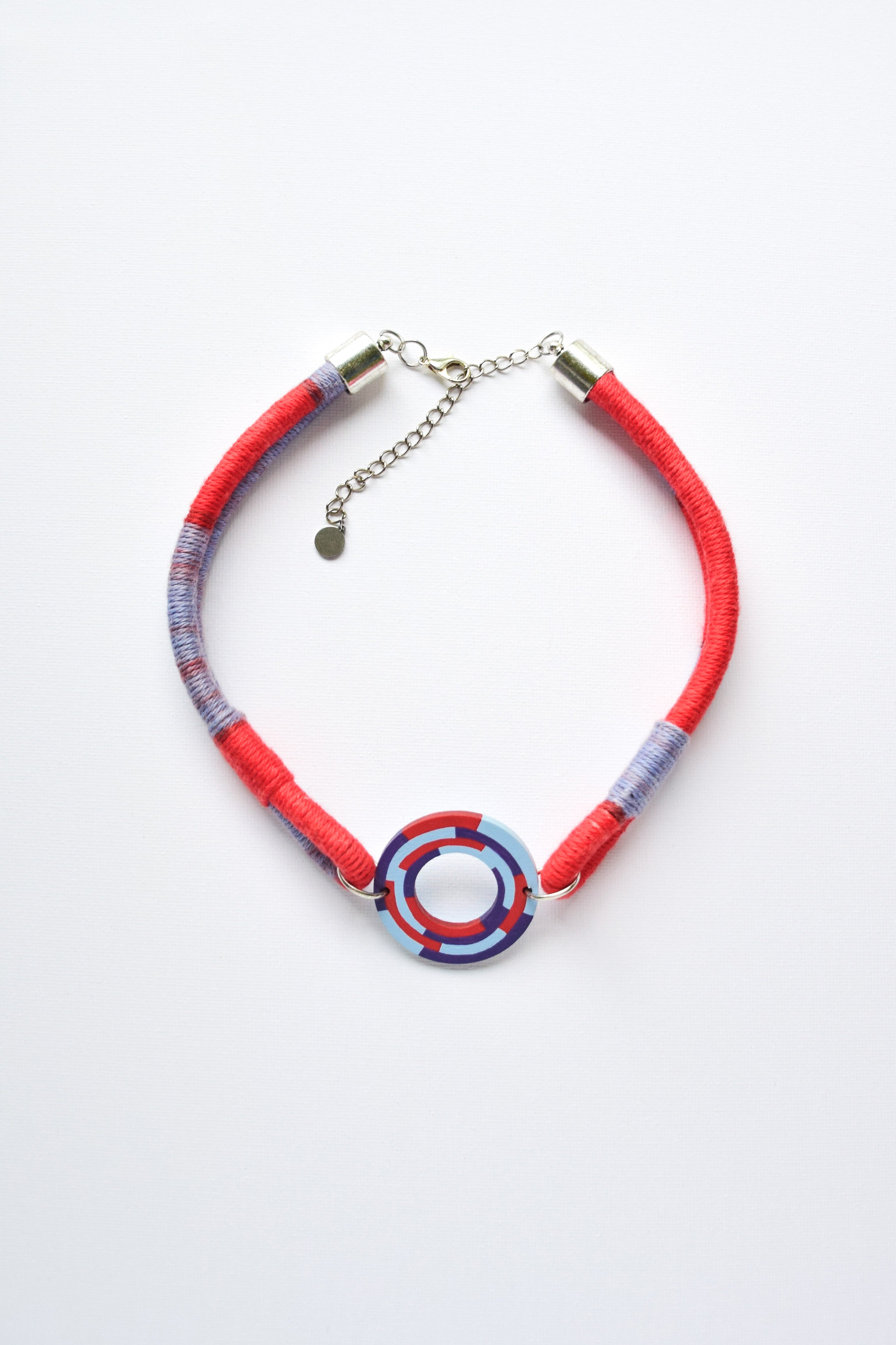 Necklace with red and blue circular designed pendant on a white background